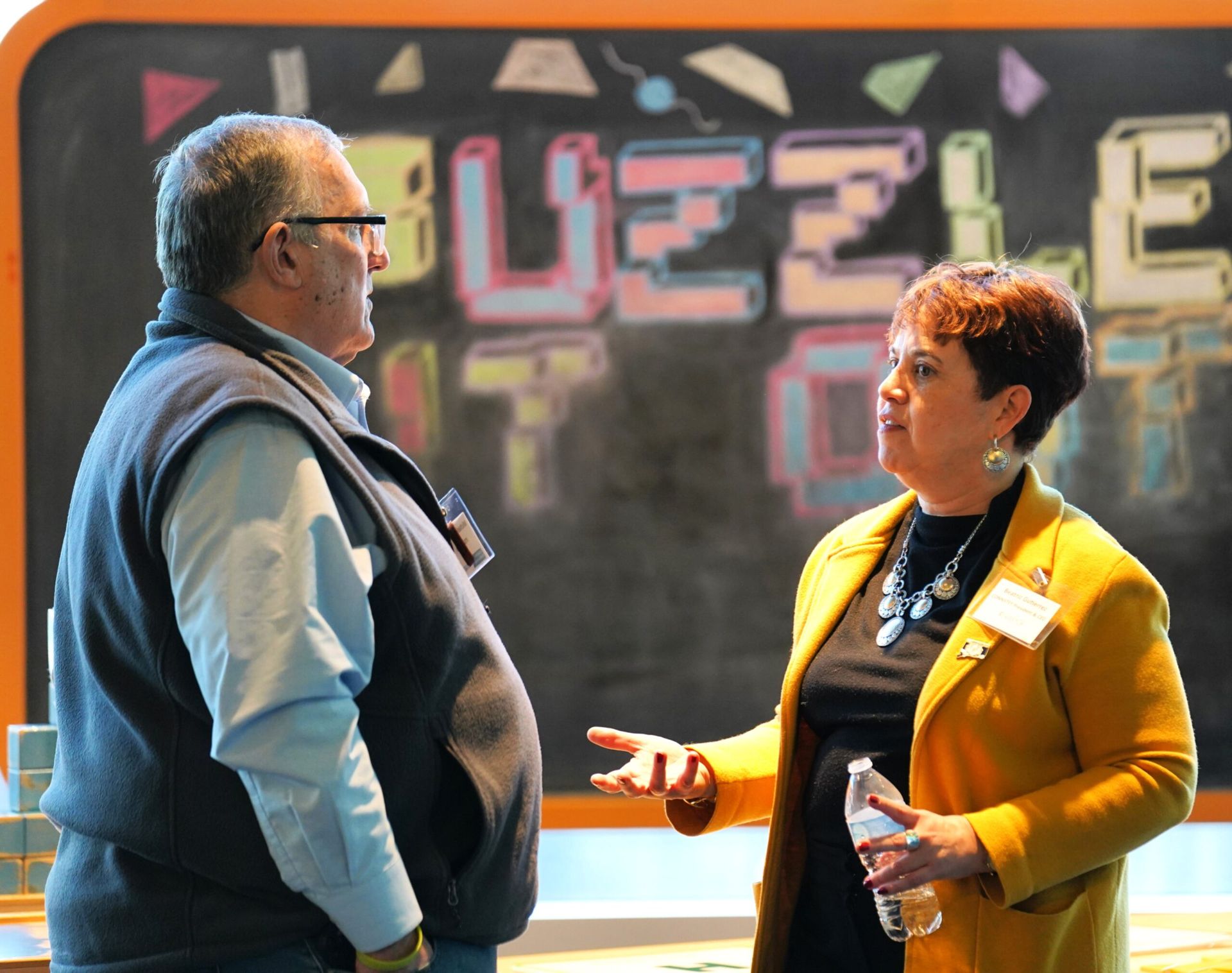 Two people conversing in front of a 