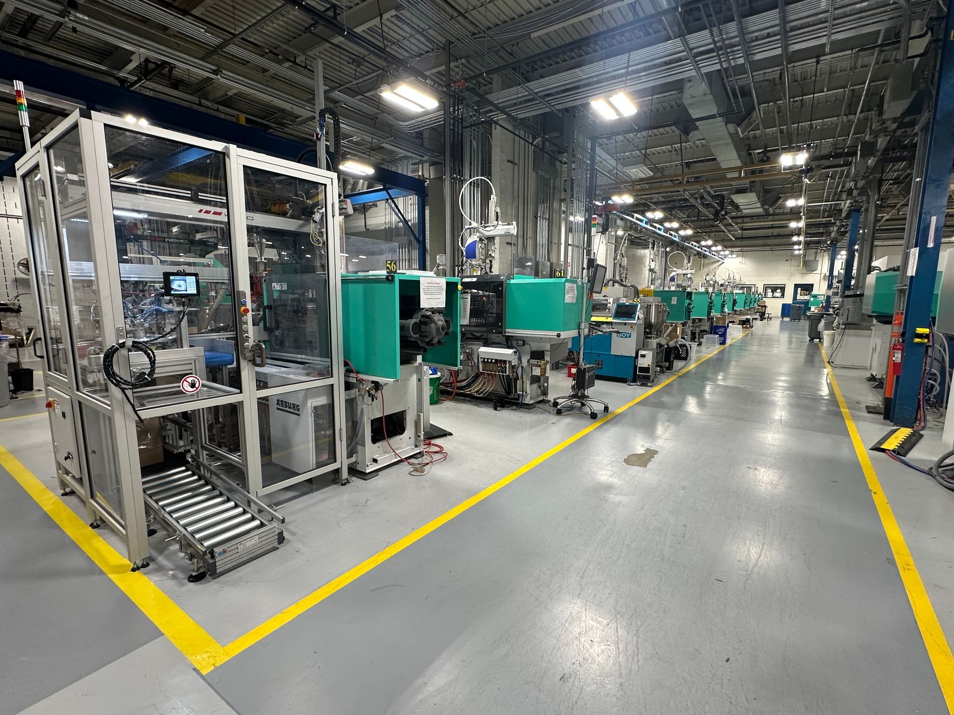 Factory floor with automated machinery and yellow floor lines.