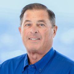 A portrait of Rick Mullins, Director, Service Delivery & Interim Director of Business Development at CONNSTEP. wearing a blue shirt smiling at the camera against a blue and white background.