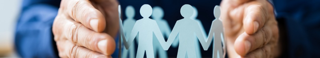 Hands cupping paper cutouts of people, symbolizing protection and community.