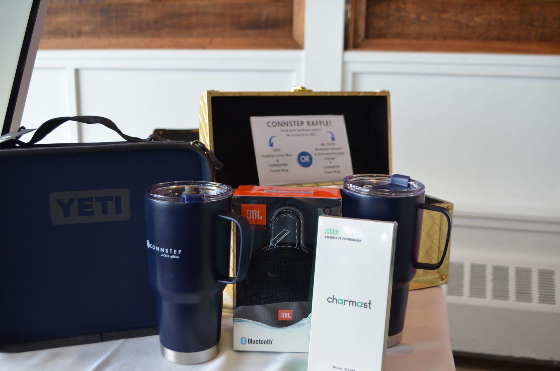 Prizes: Yeti cooler bag, two navy tumblers, a speaker box, and a gold box with a sign.