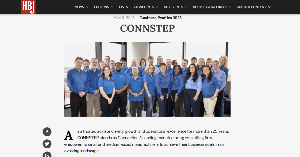 Group of people wearing blue shirts posing for a photo. Company name 