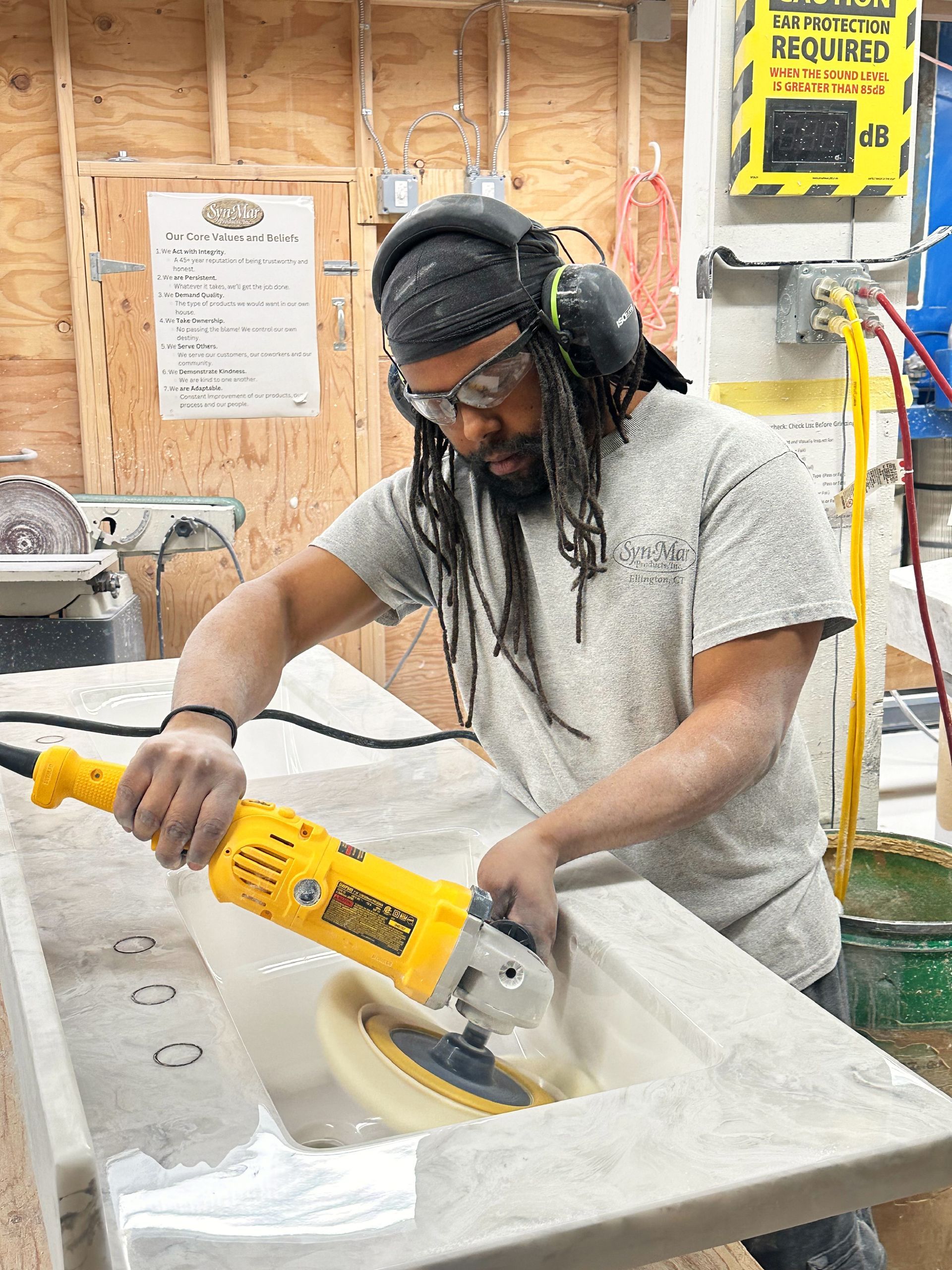 Worker using a polishing wheel on a vanity top.