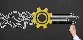 A yellow gear transforms tangled lines into straight arrows on a black chalkboard, hand drawing the arrows.