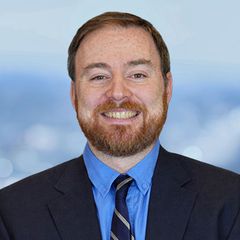 A portrait of Rob Blakely, Chief Financial Officer at CONNSTEP, smiling,  looking at the viewer. Blurred background.