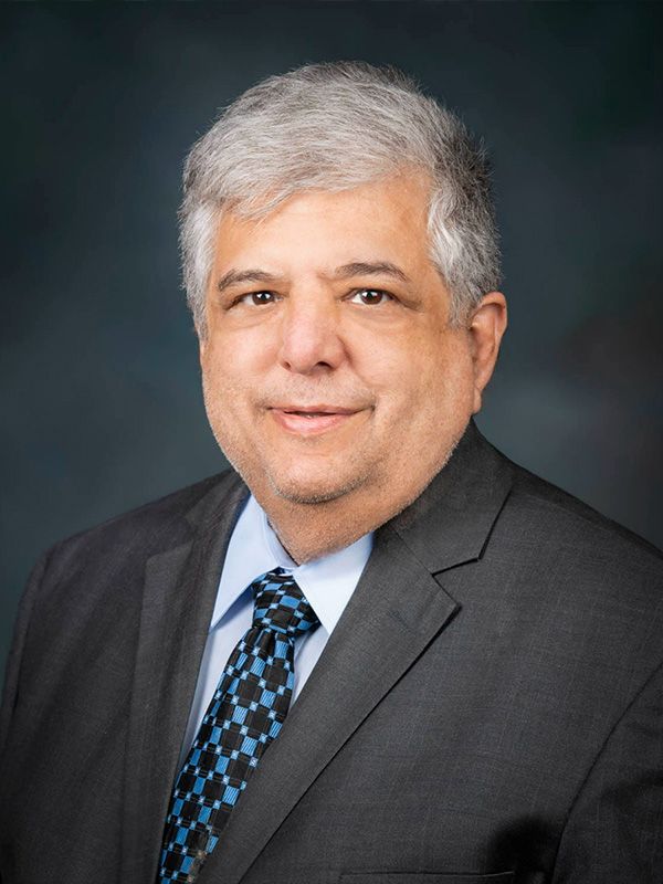 A man in a suit and tie is smiling for the camera.