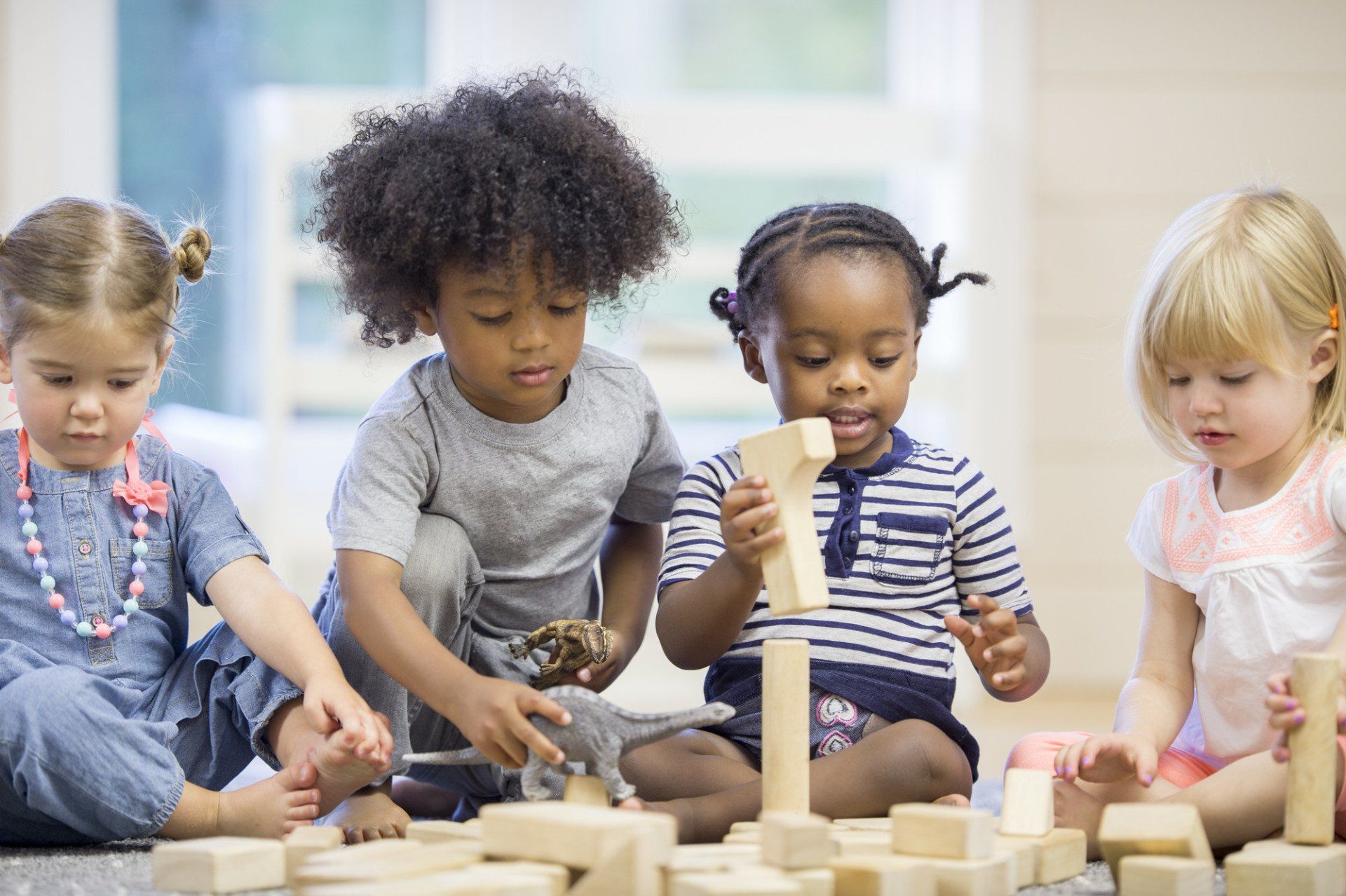  Preschool children are playing and learning in a classroom, building a tower with wooden blocks.