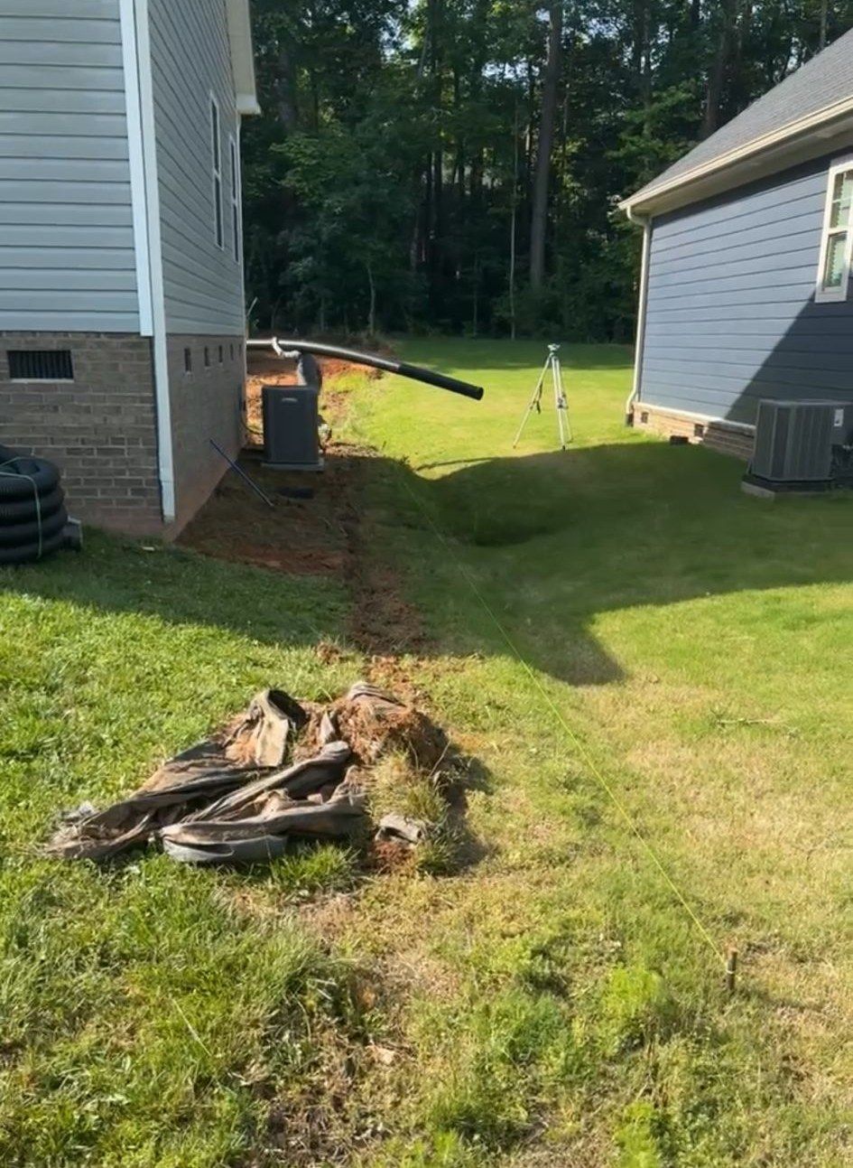 A pile of tires is sitting in the grass in front of a house.