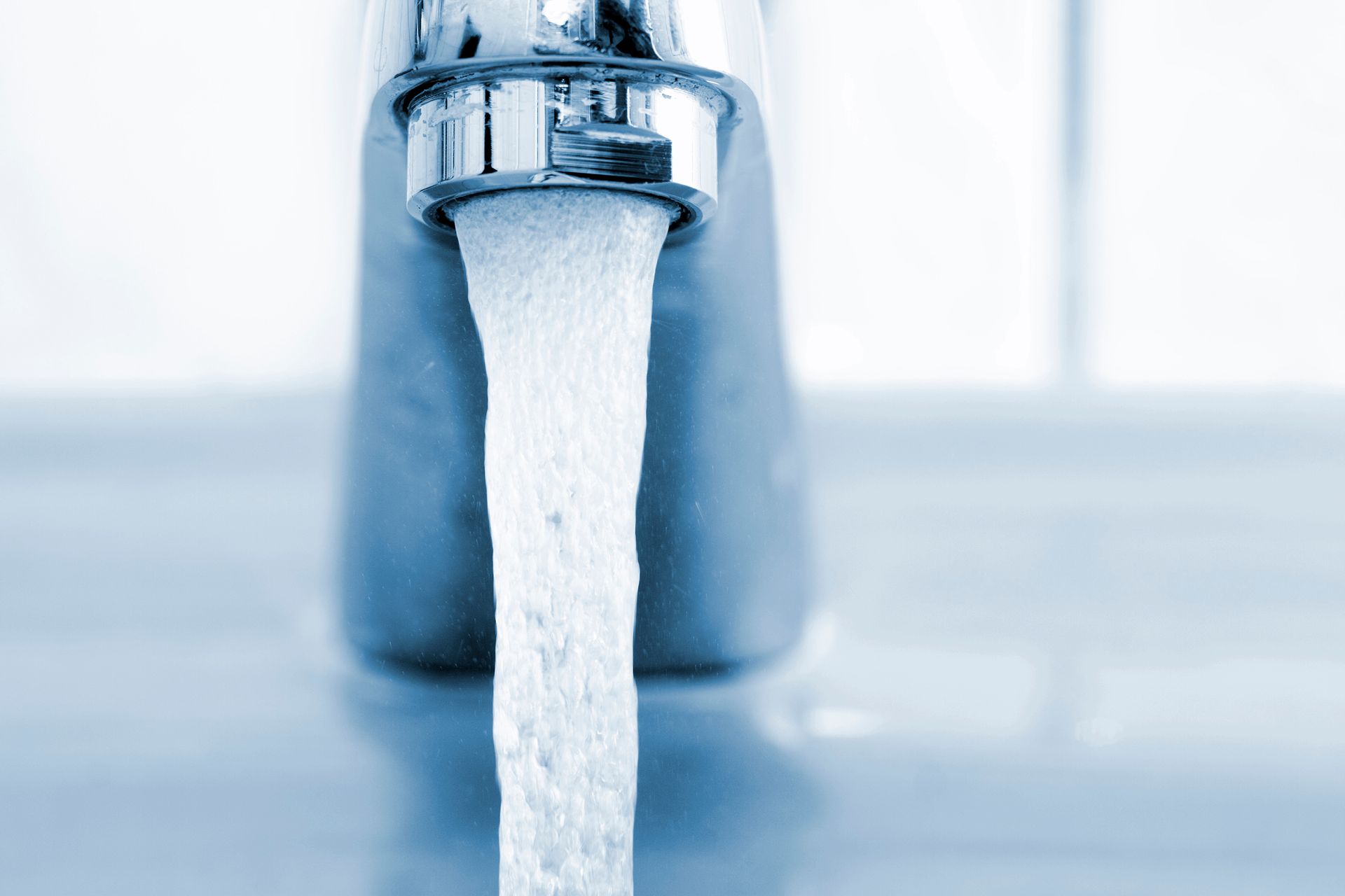 Water is running from a faucet in a bathroom.