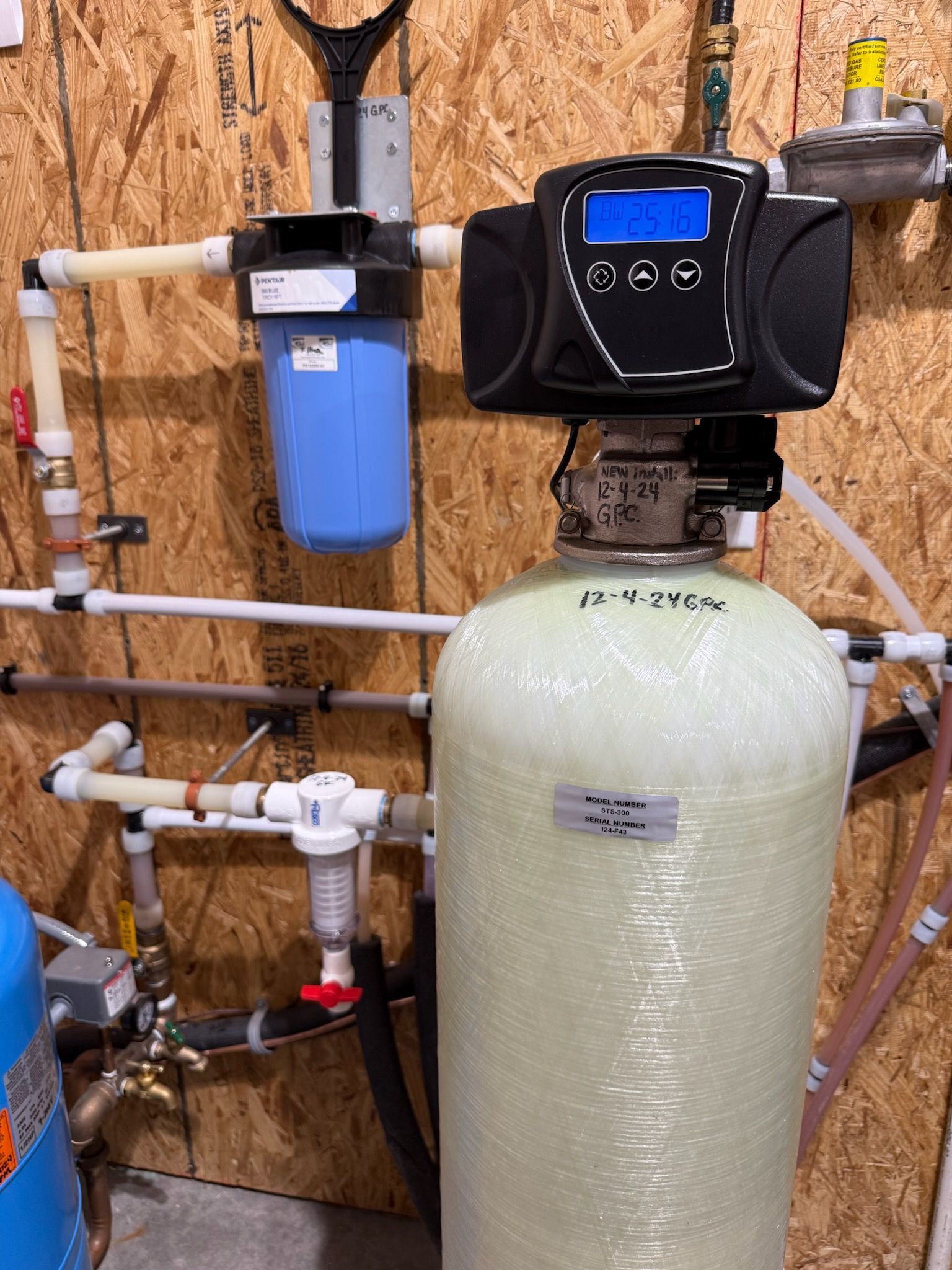 Water filtration system with a blue filter, control panel, and white tank.