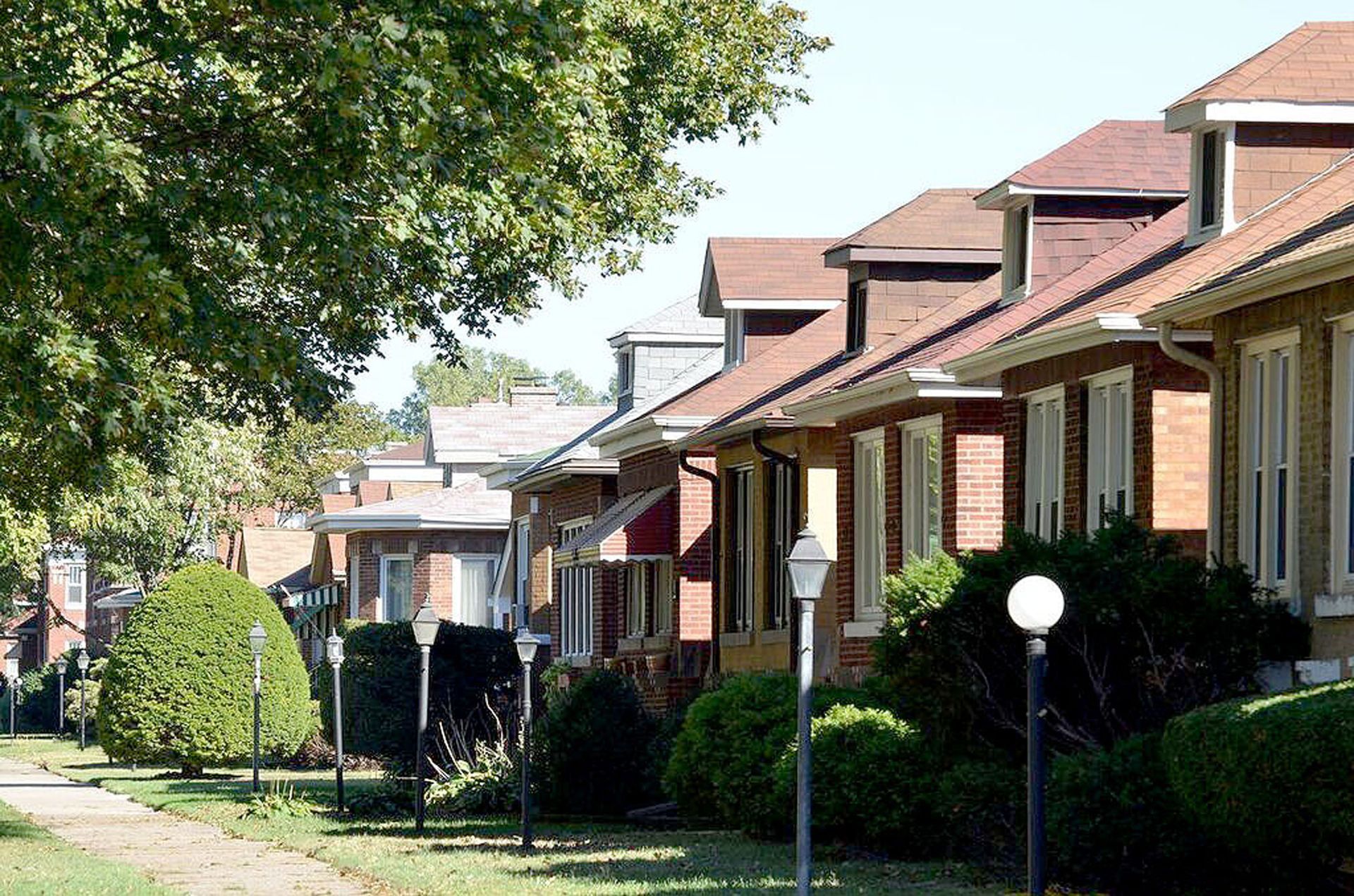 A woman is sitting at a bar holding two drinks.