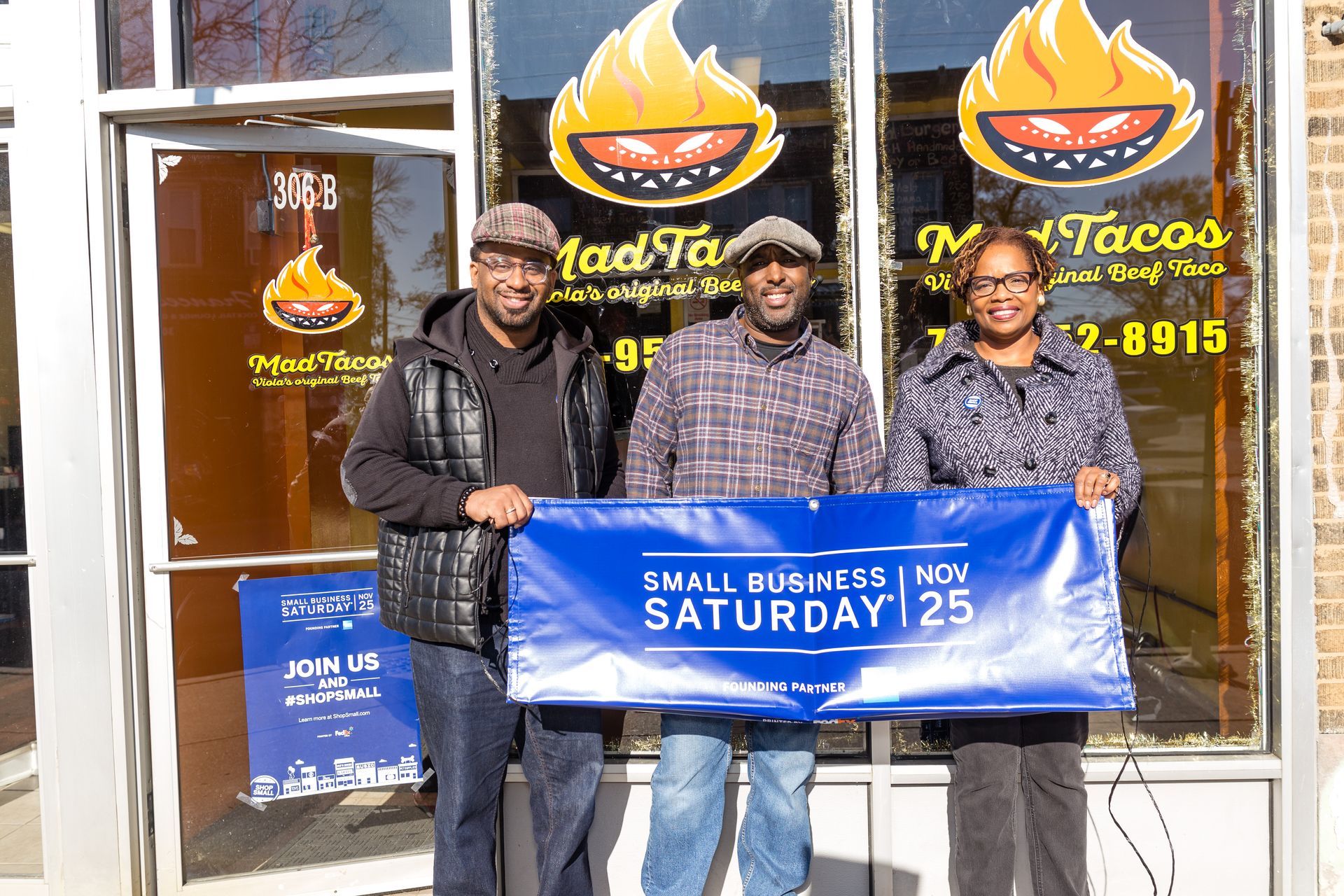 A woman is sitting at a bar holding two drinks.