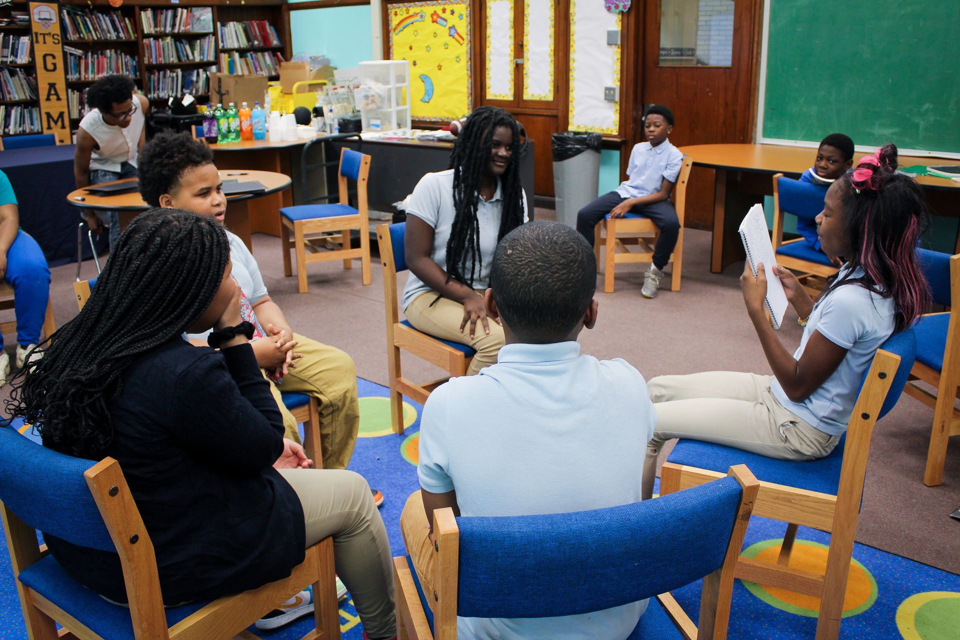 Children  in classroom engaging with one another in a circle.