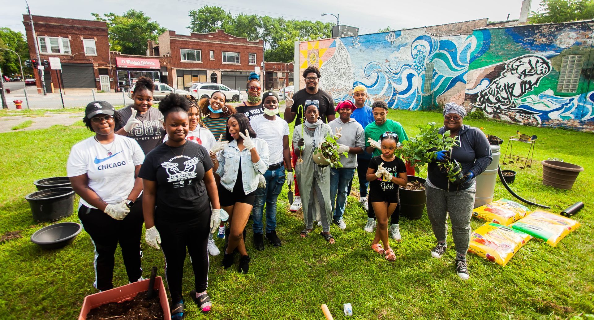A woman is sitting at a bar holding two drinks.