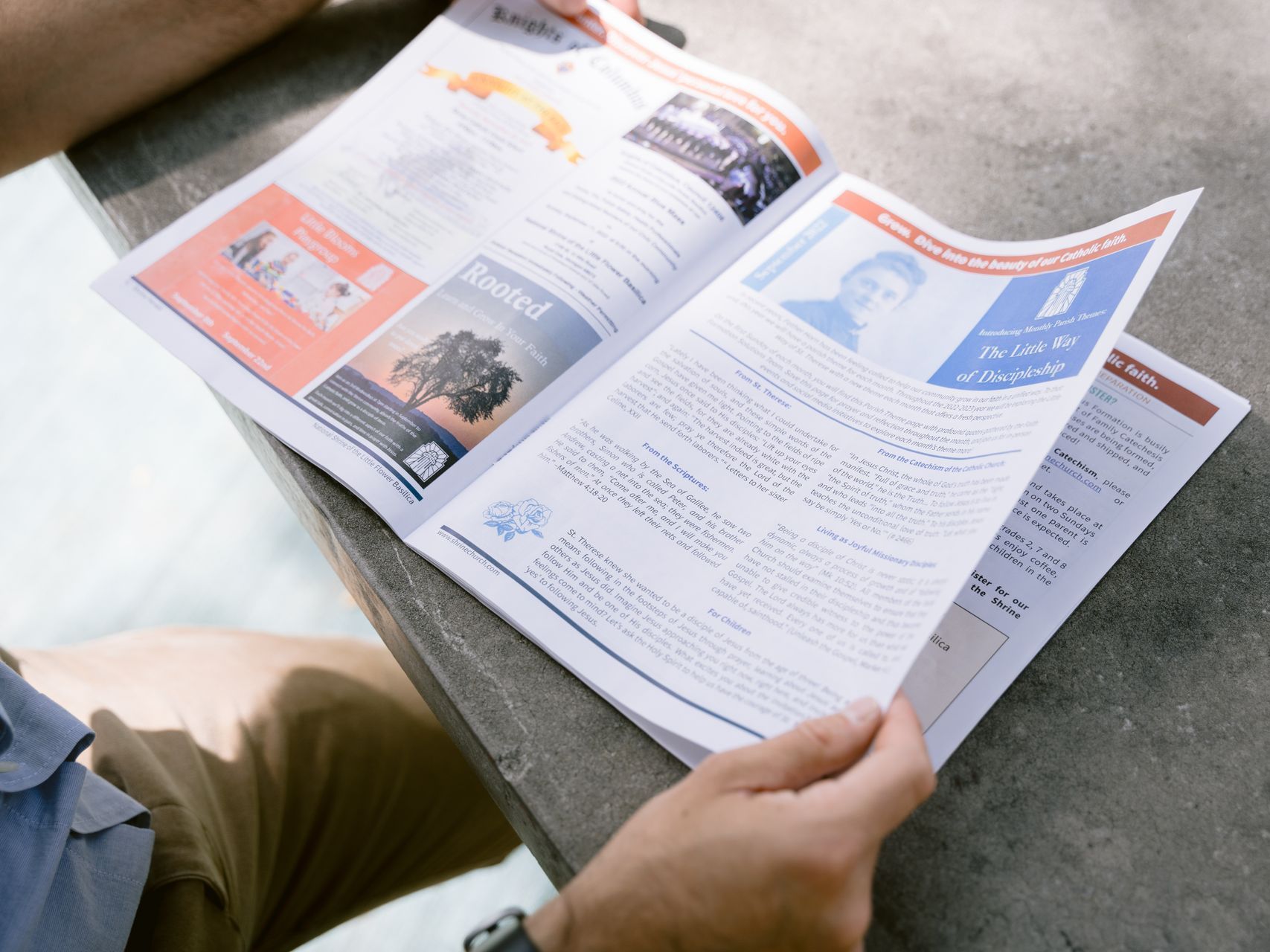 Person reading an open magazine with colorful pages at a table
