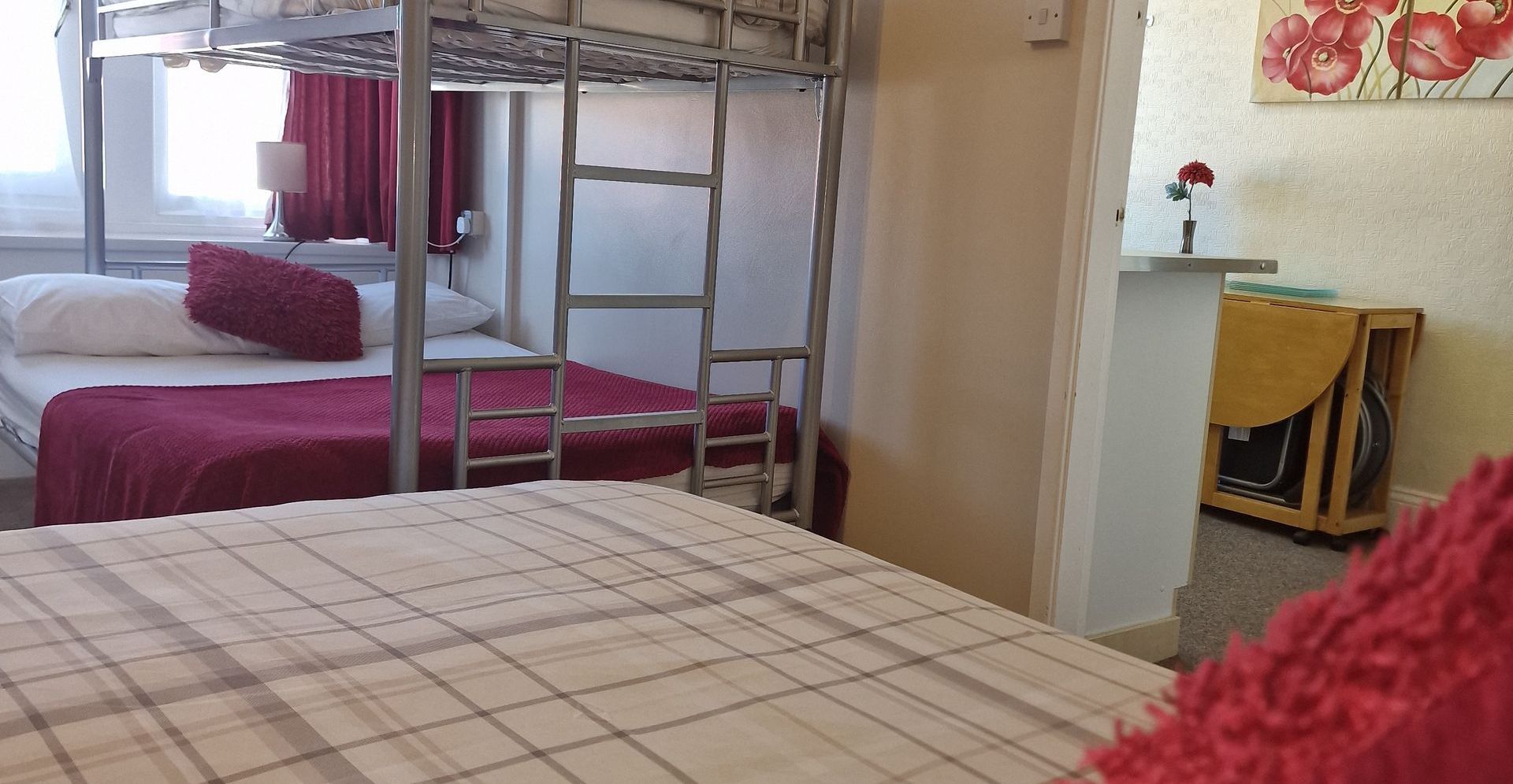 A bedroom with two bunk beds and a bed.