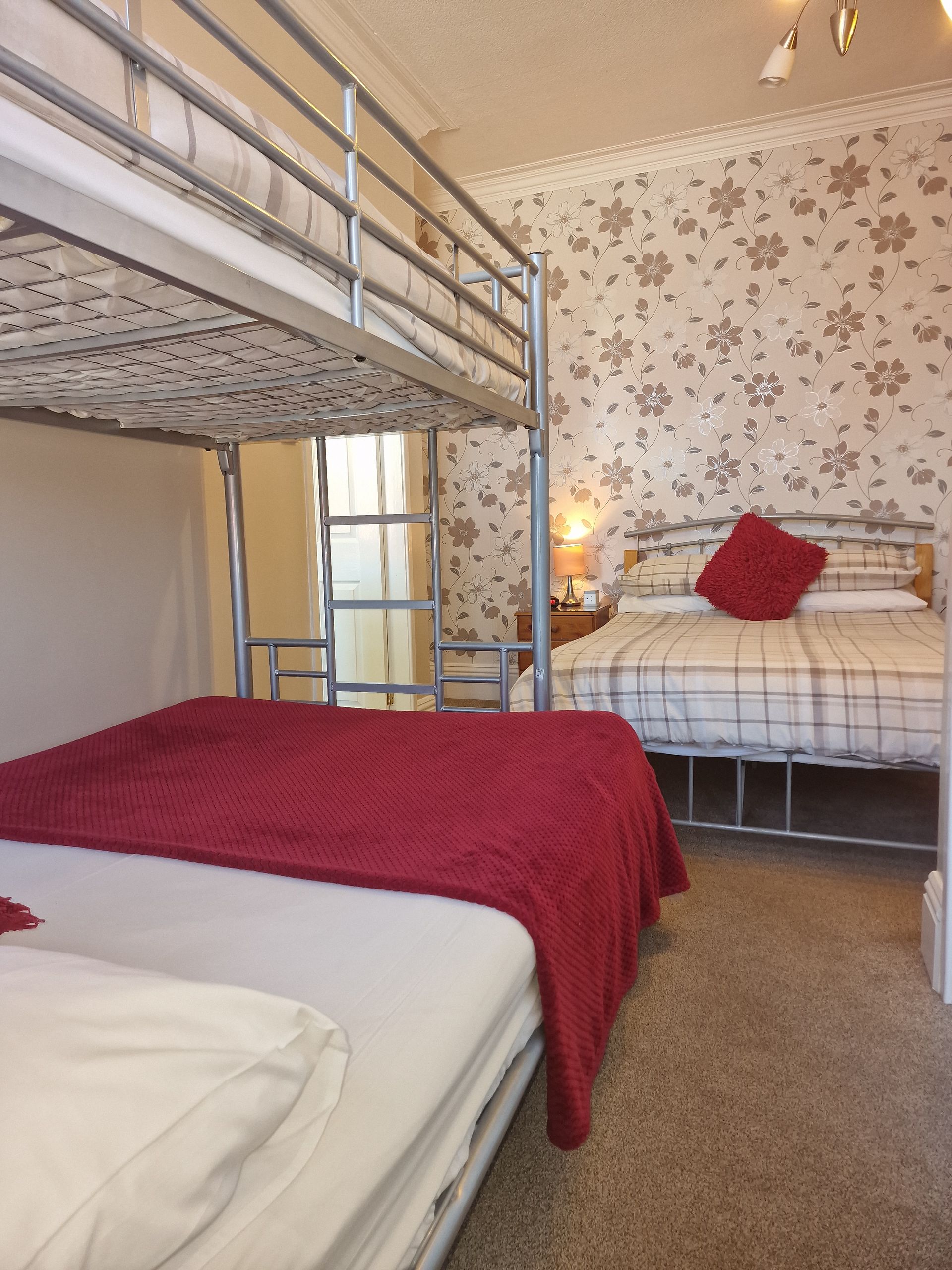 A bedroom with a bunk bed and two beds