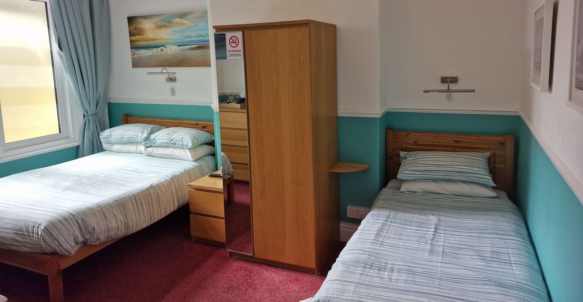 A bedroom with two beds and a wardrobe.