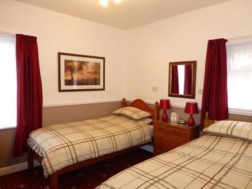 A bedroom with two beds and a mirror