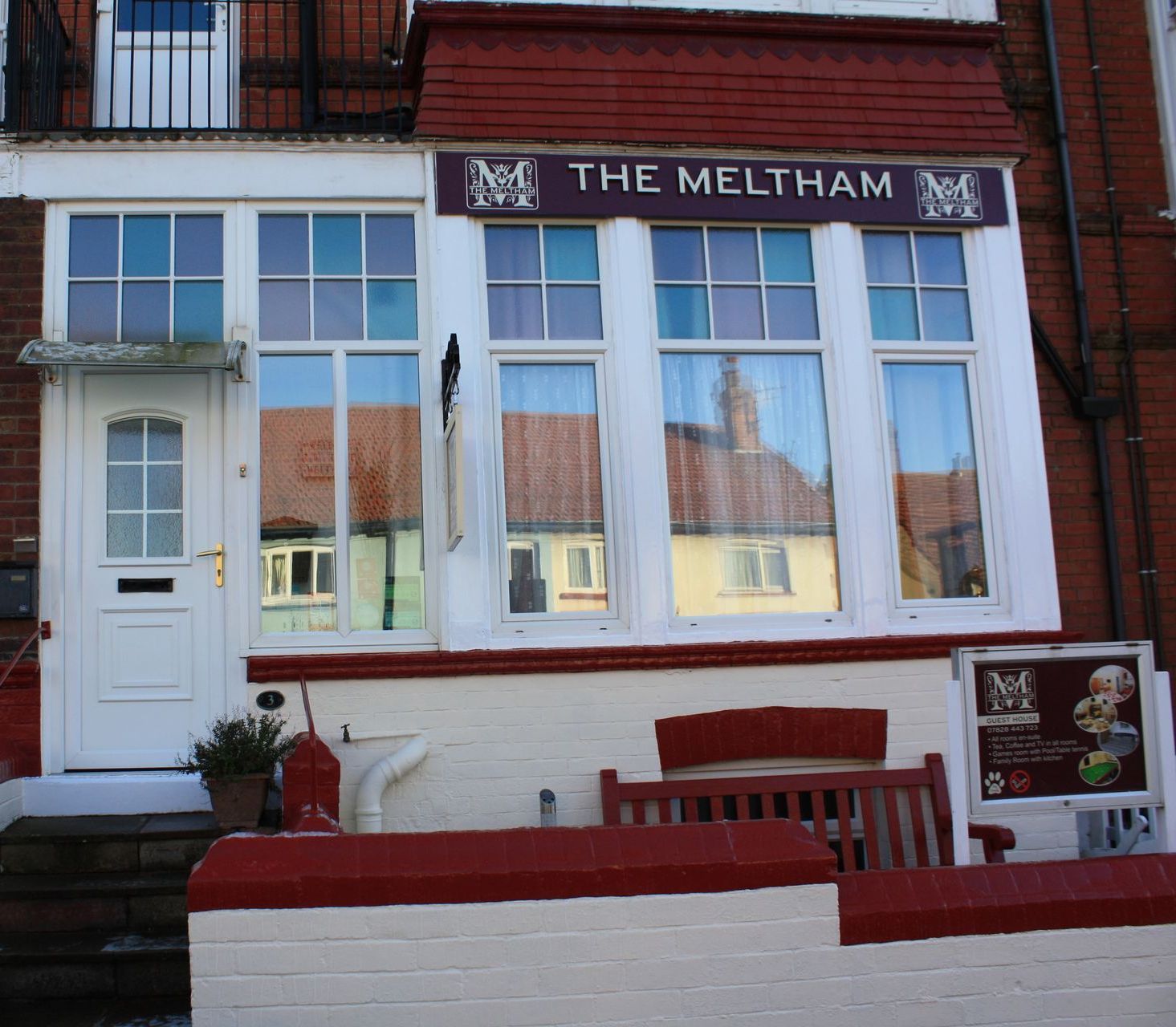 A large building with a lot of windows and a bench in front of it.