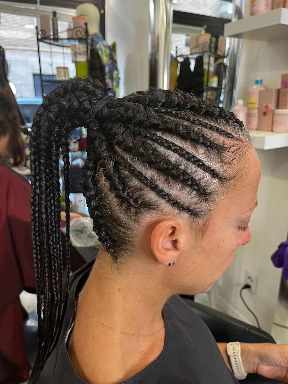 Una donna si sta facendo intrecciare i capelli in una coda di cavallo in un salone.