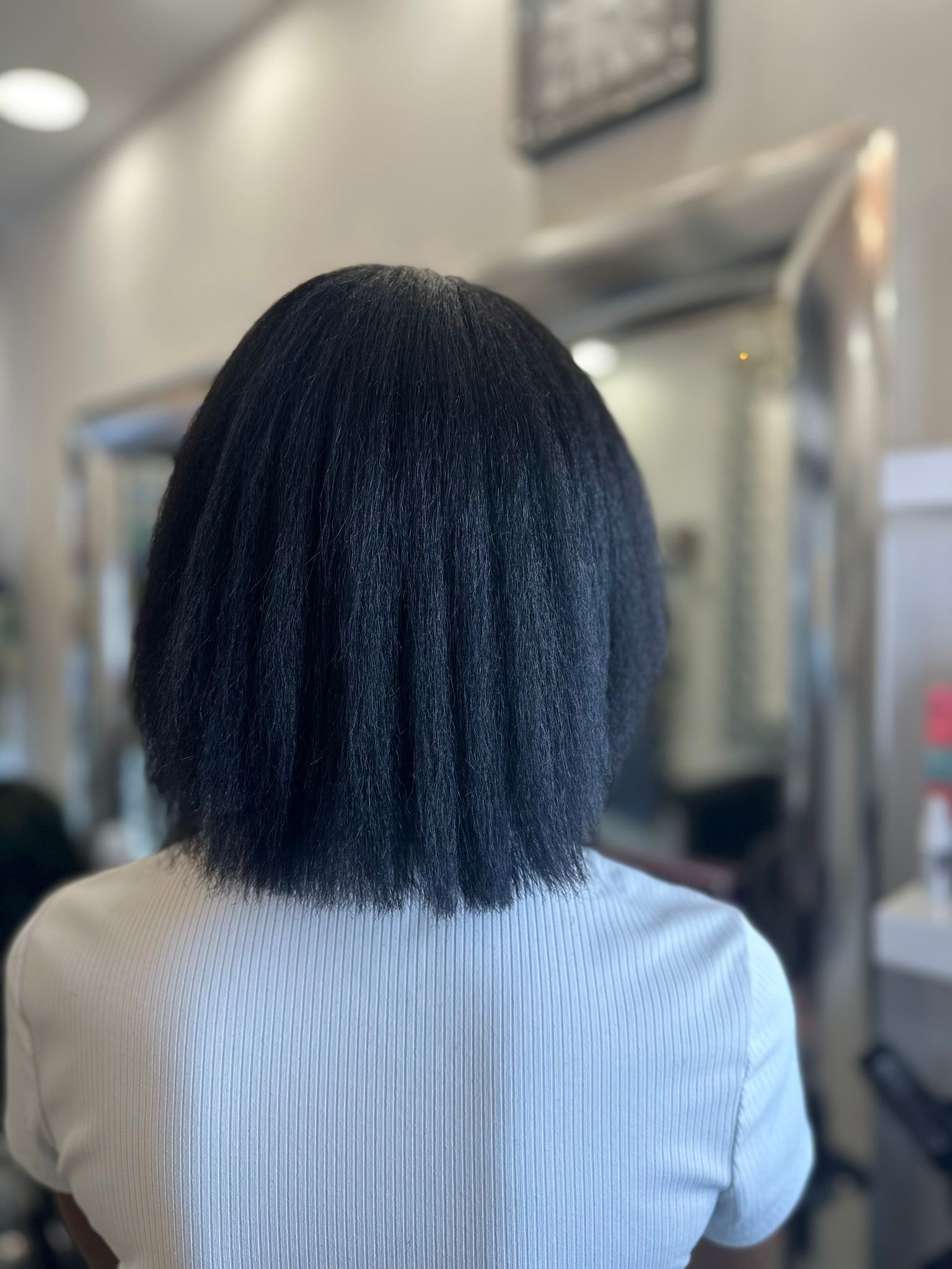 La parte posteriore della testa di una donna con i capelli corti in un salone.