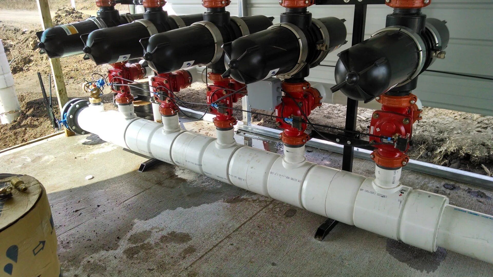 A row of pipes with red valves attached to them