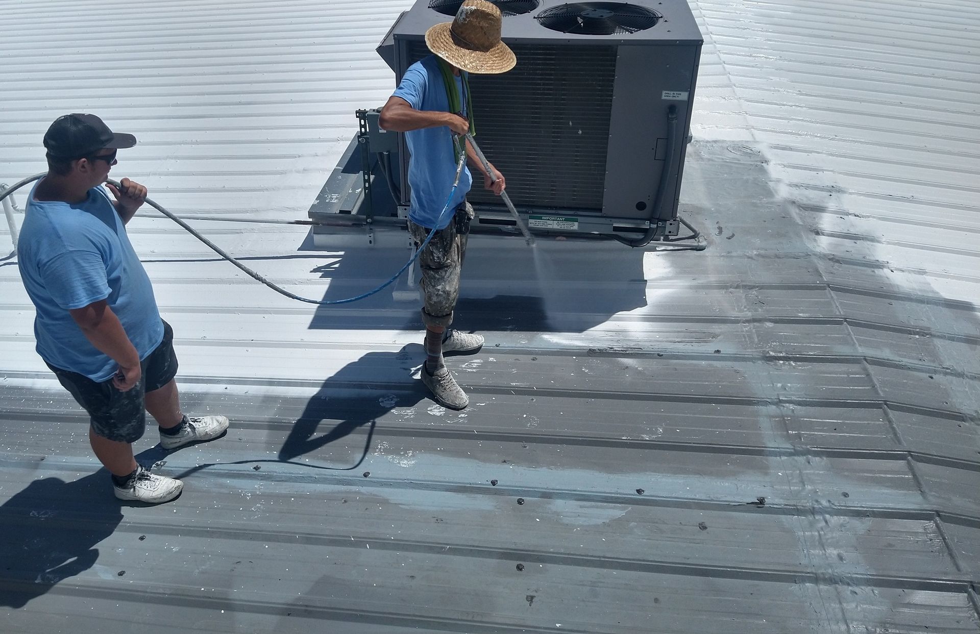 Two men are cleaning the roof of a building.