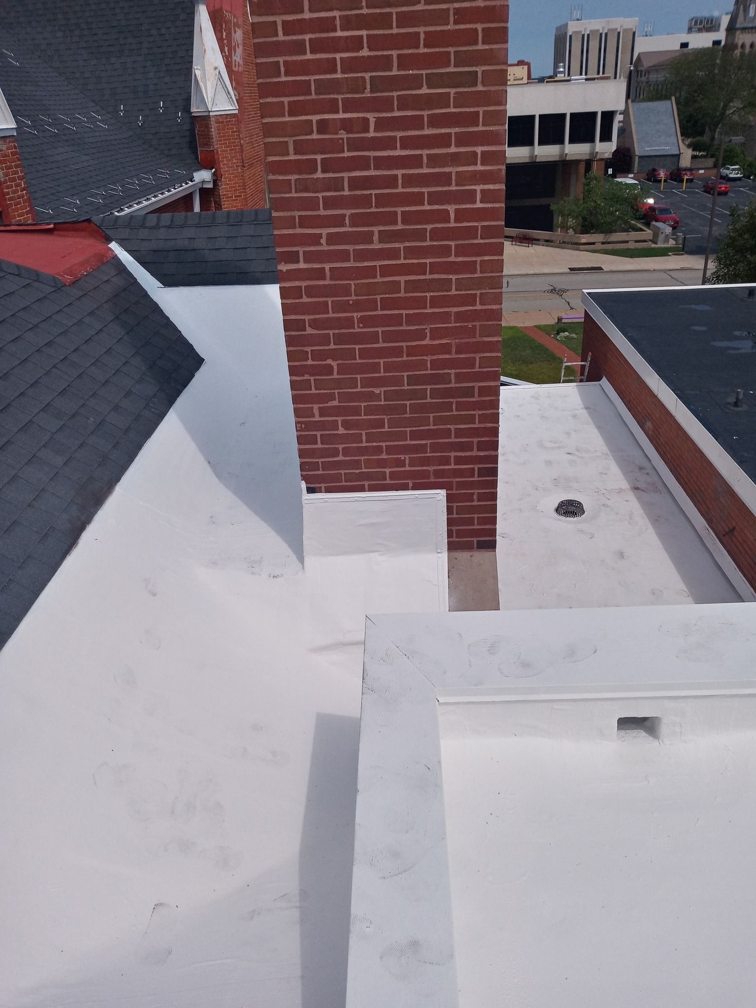 A brick chimney on top of a white roof