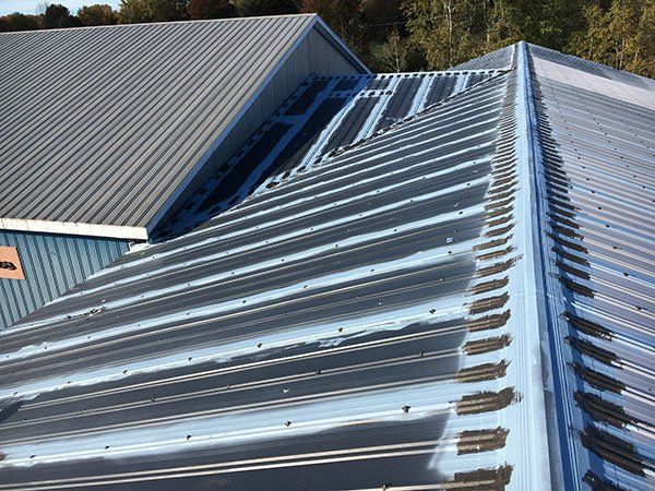 The roof of a building with a gray roof and a blue roof