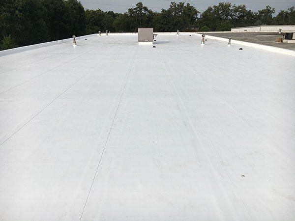 A white roof with a chimney on top of it.