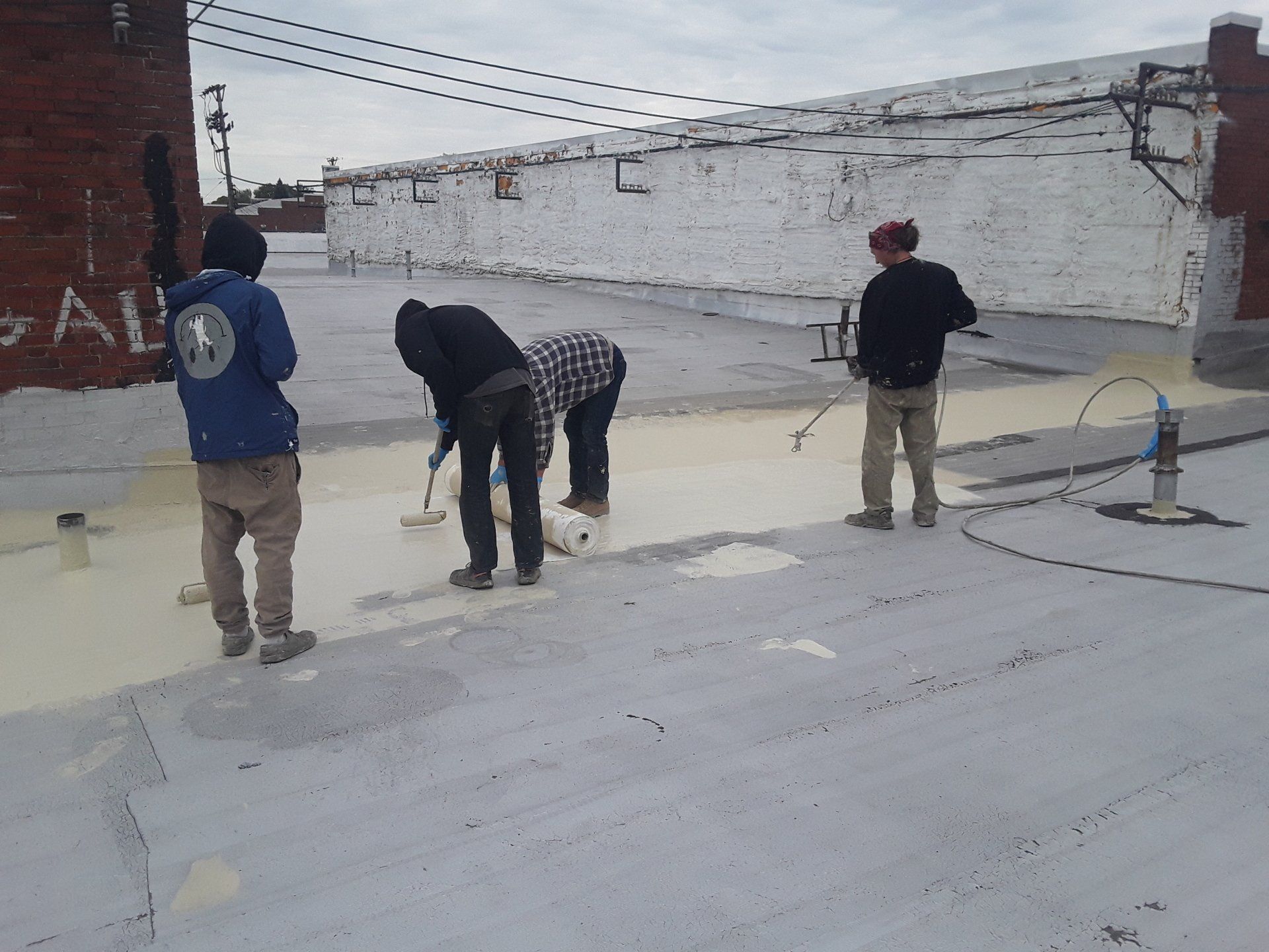 A group of people are working on a roof and one of them has the number 10 on his back