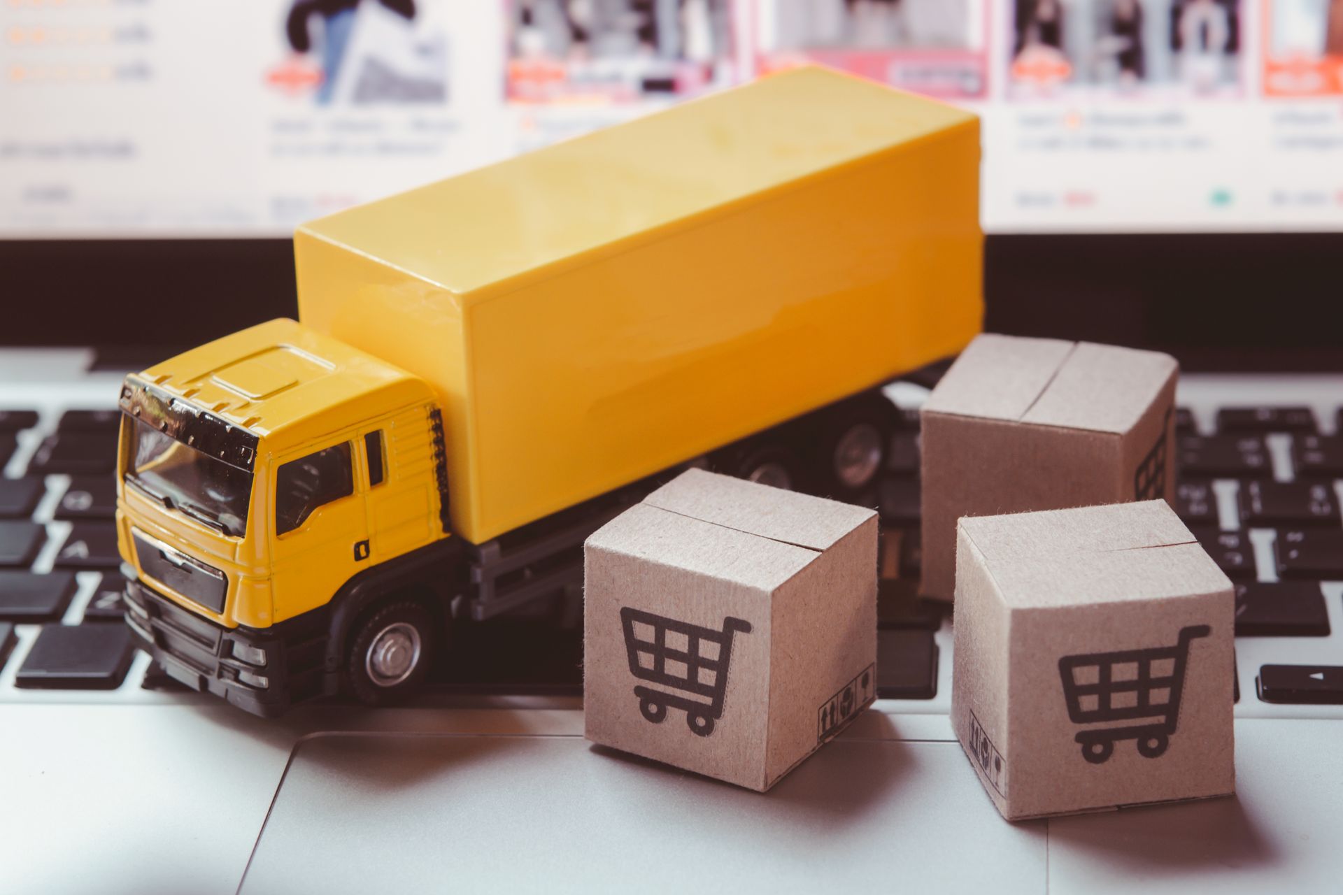 A toy truck is sitting on top of a laptop keyboard.