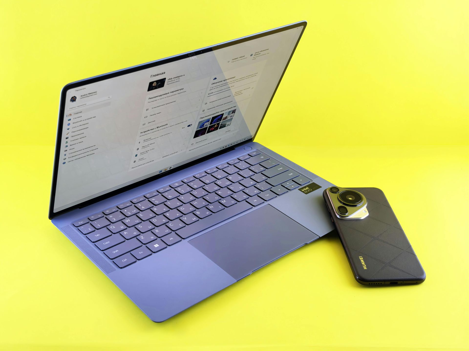 Purple laptop and smartphone on a yellow surface, laptop screen open, smartphone resting alongside.