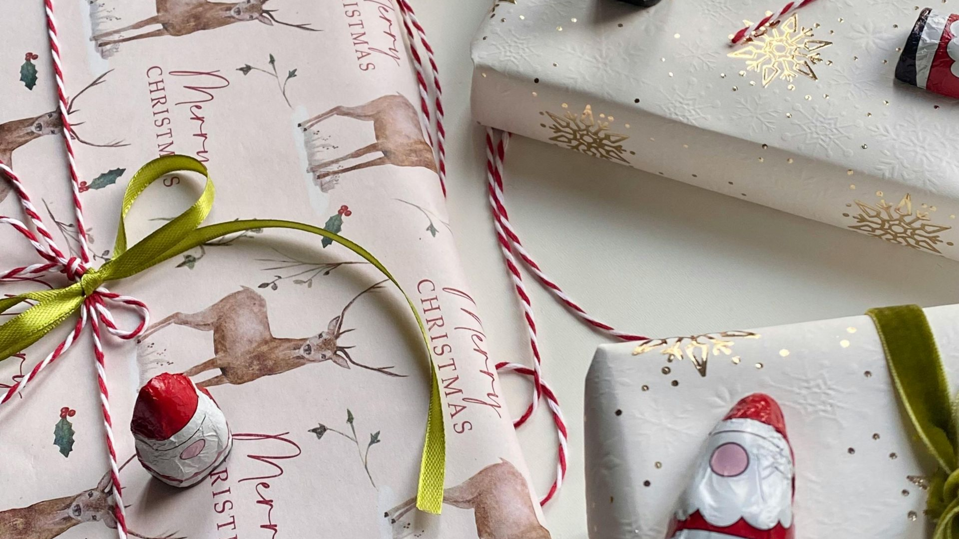 Wrapped Christmas gifts with decorative paper, ribbons, and candy ornaments.