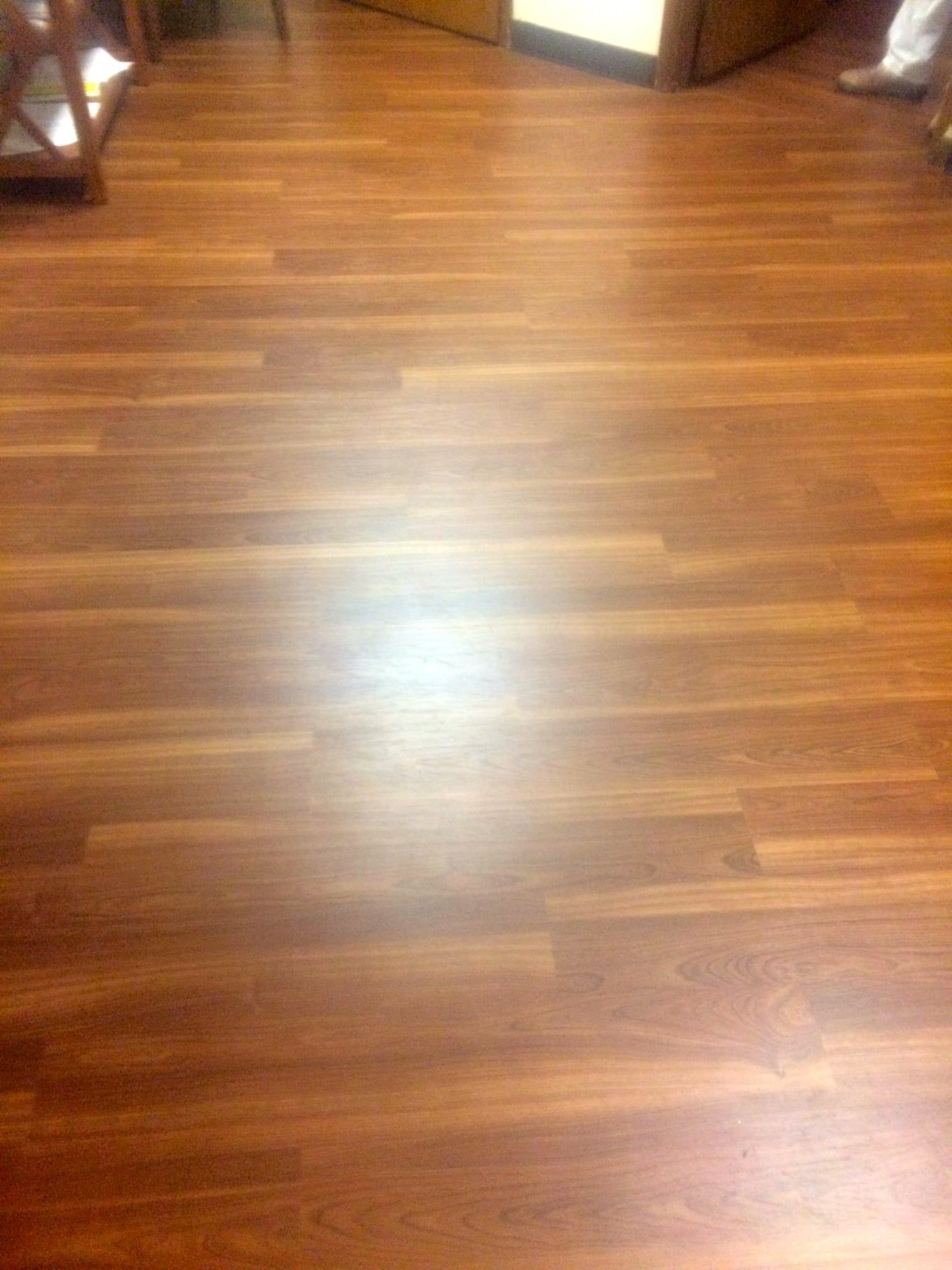 A person is standing on a wooden floor in a room.