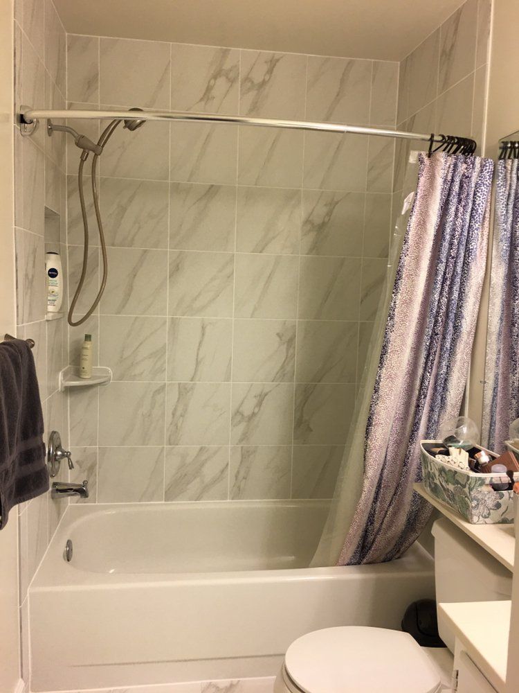 A bathroom with a bathtub , toilet and shower.