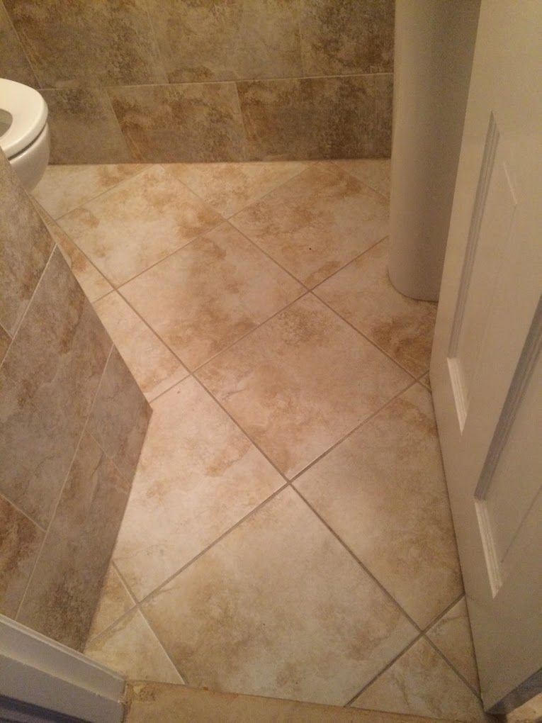 A bathroom with a tiled floor and a toilet.