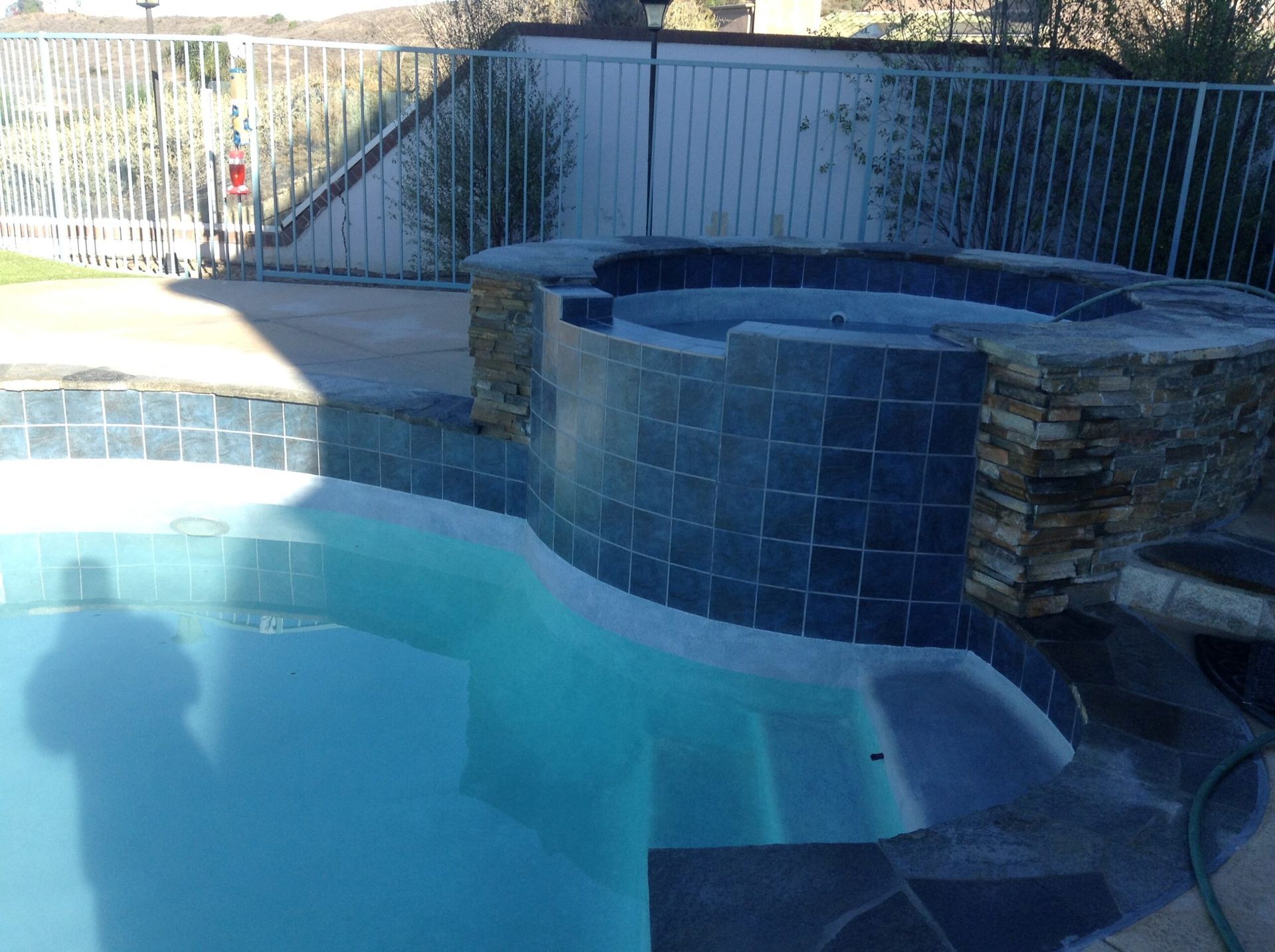 A swimming pool with a hot tub in the middle of it