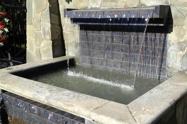 There is a waterfall in the middle of a pool.