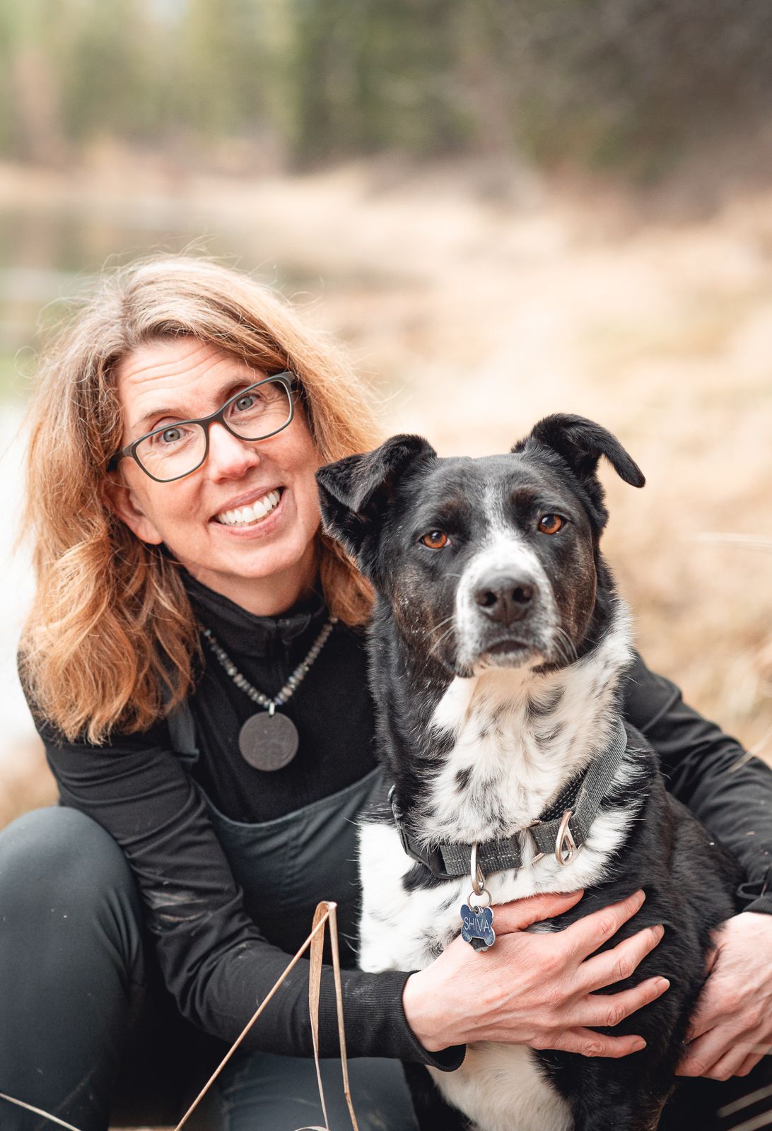 Woman receiving a facial massage with hands on her face. White top, blonde hair, eyes closed.