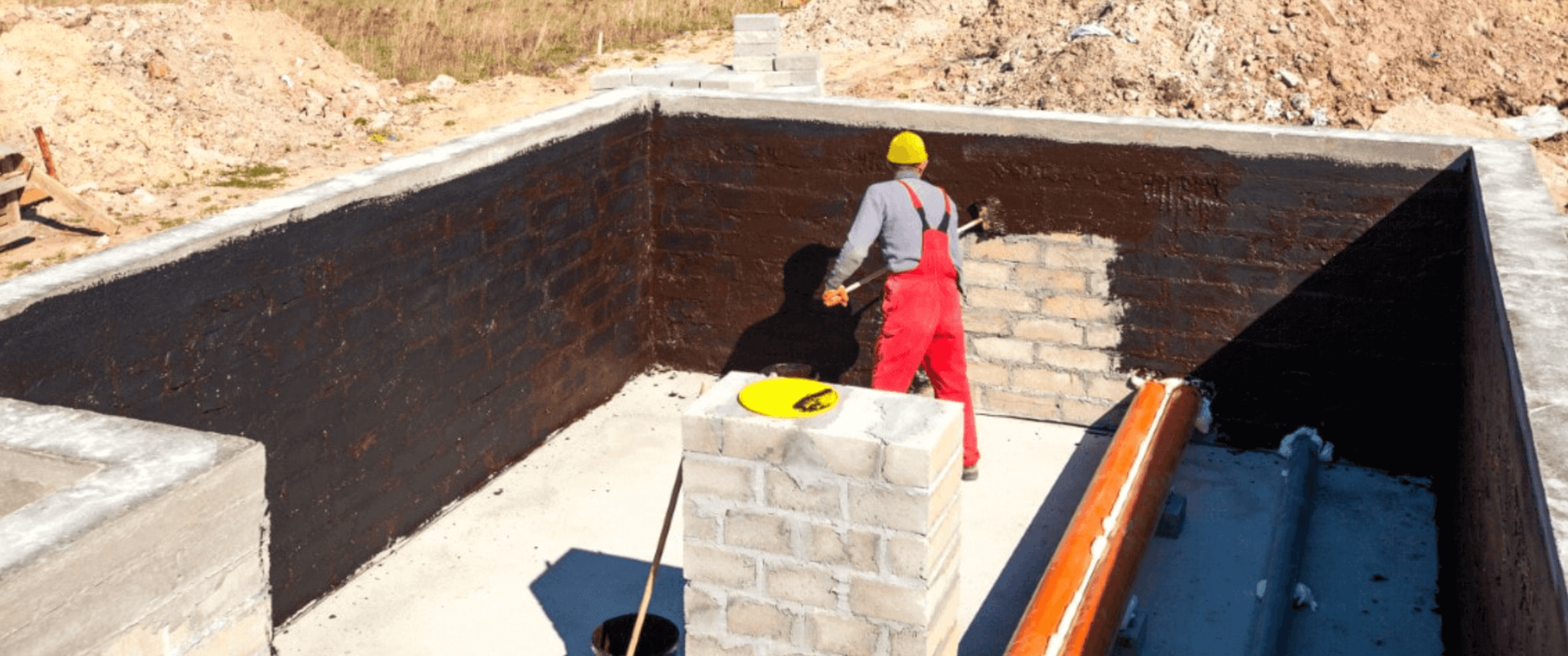 Professional contractor water proofing a concrete basement