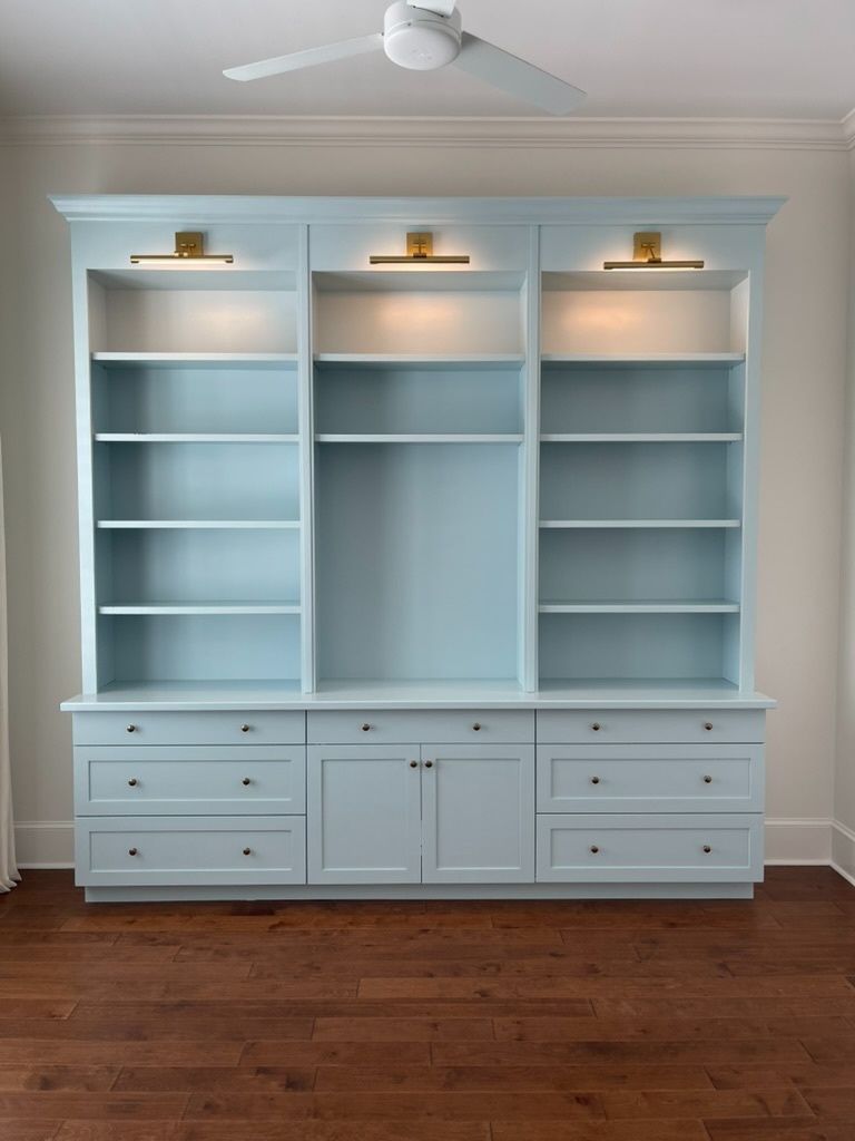 There is a ceiling fan above the bookshelf in the room.