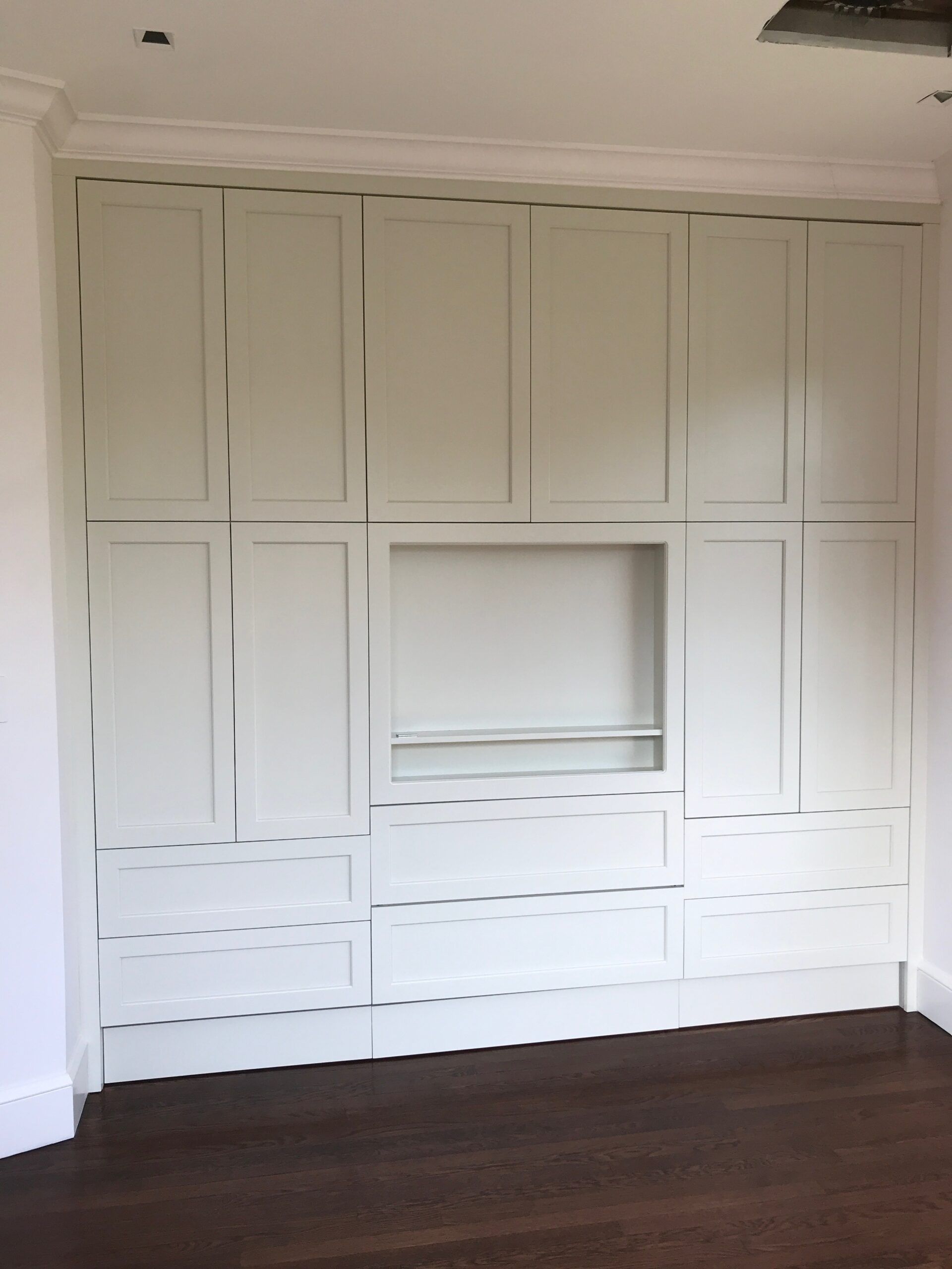 A room with a lot of white cabinets and drawers