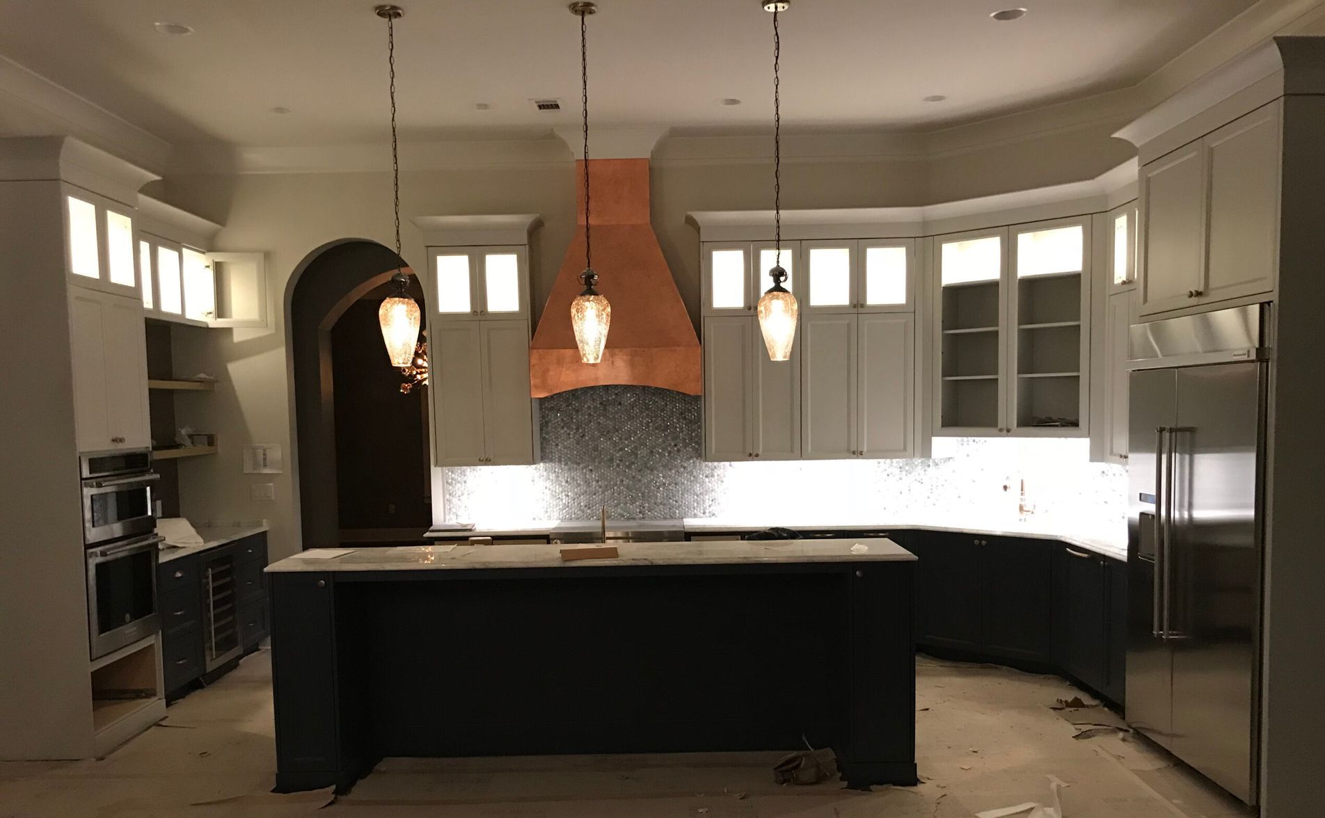 A kitchen with a large island and a copper hood.