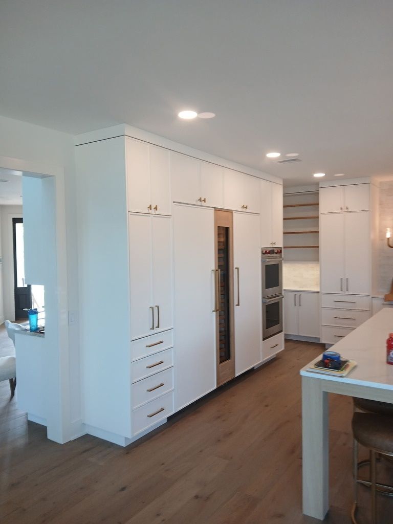A kitchen with white cabinets and stainless steel appliances