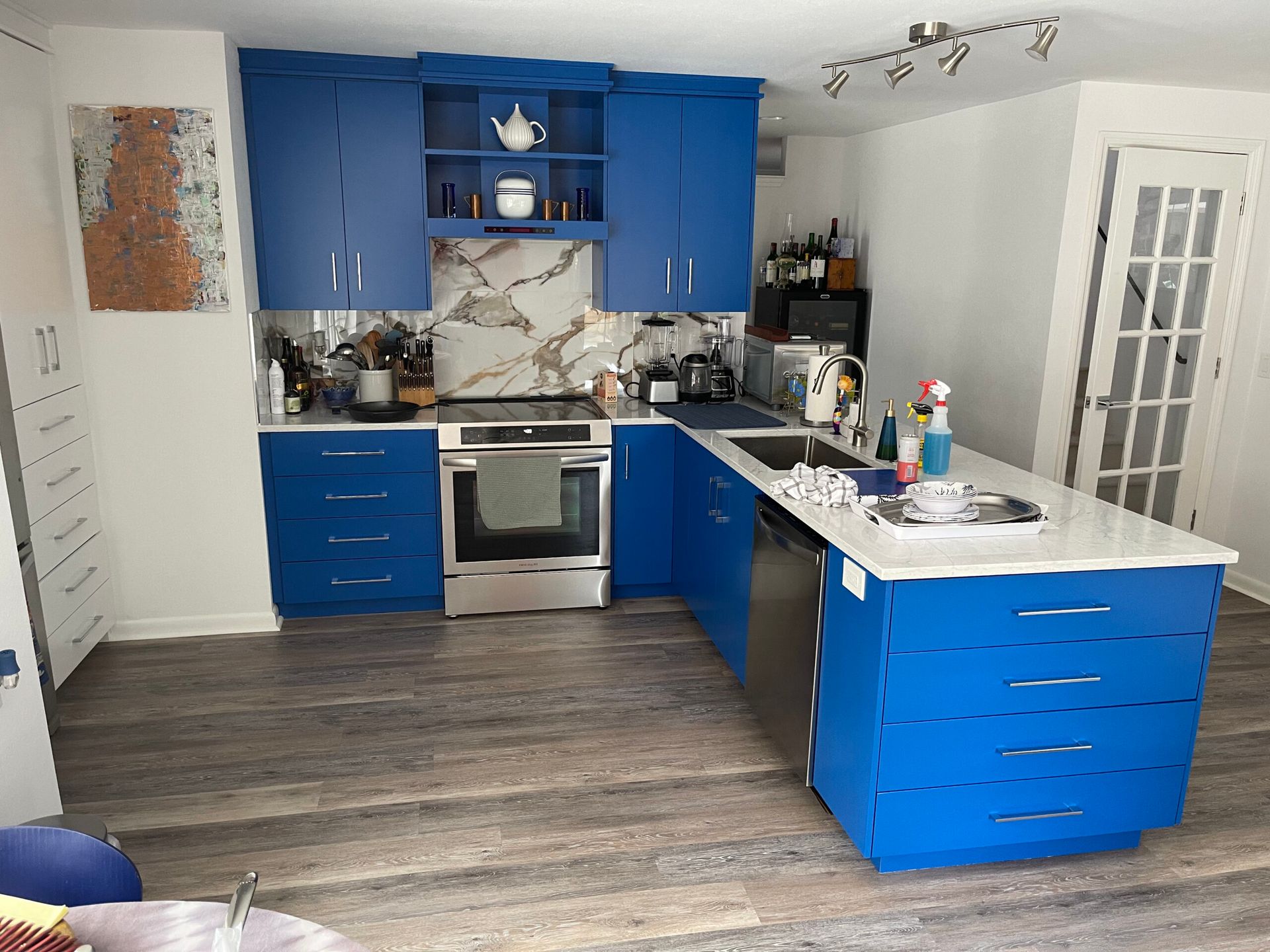 A kitchen with blue cabinets and stainless steel appliances
