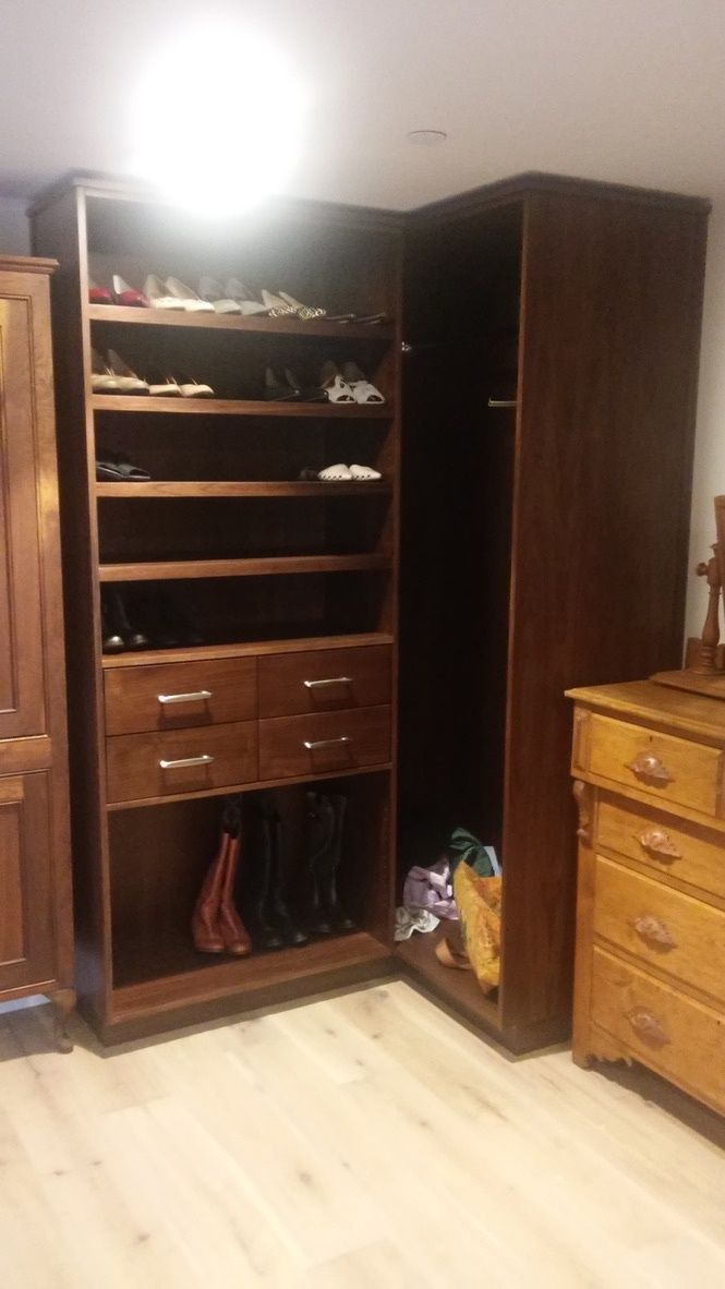 A walk in closet with lots of shelves and drawers and a dresser.