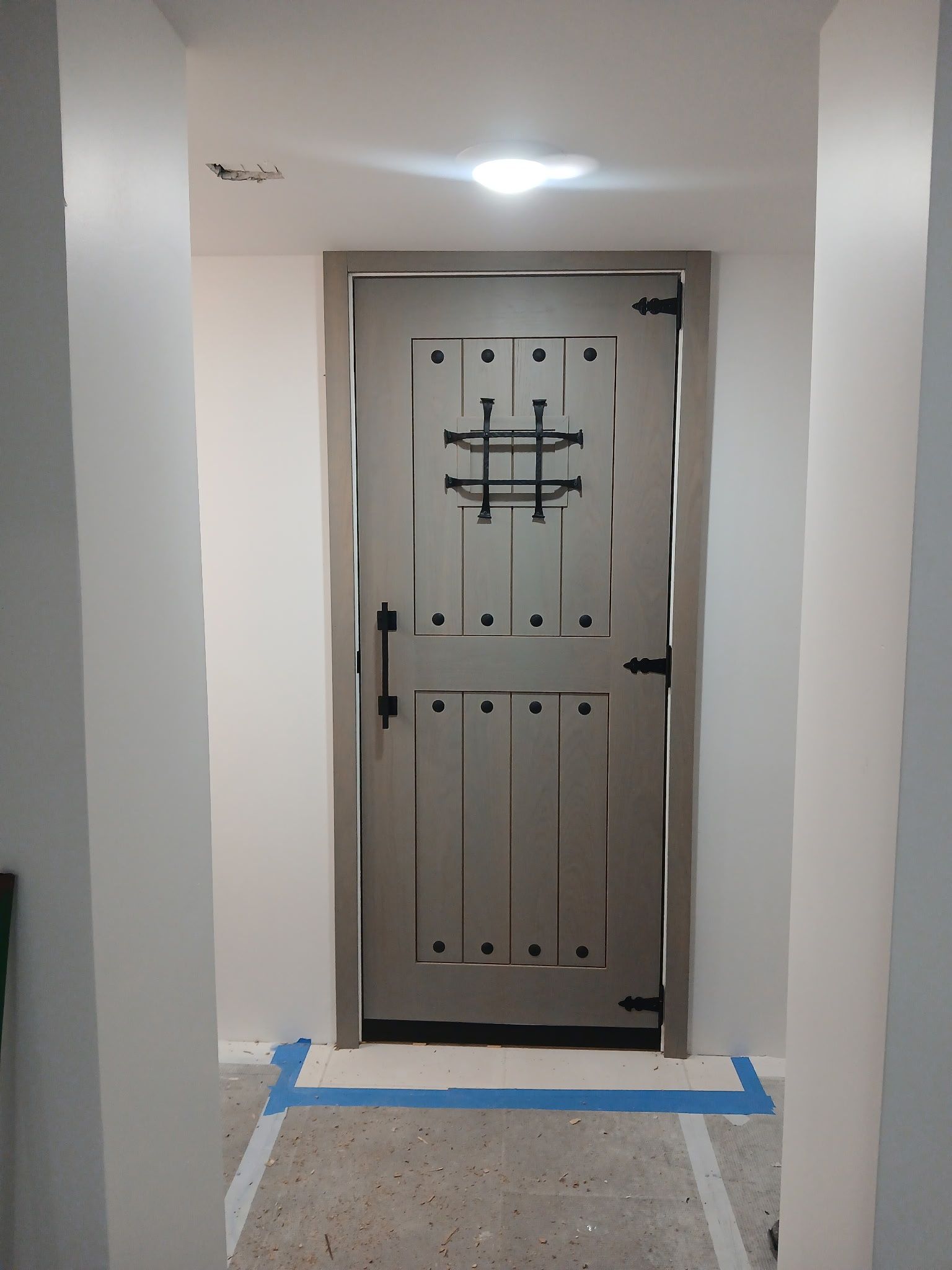 A door with a cross on it is in a hallway