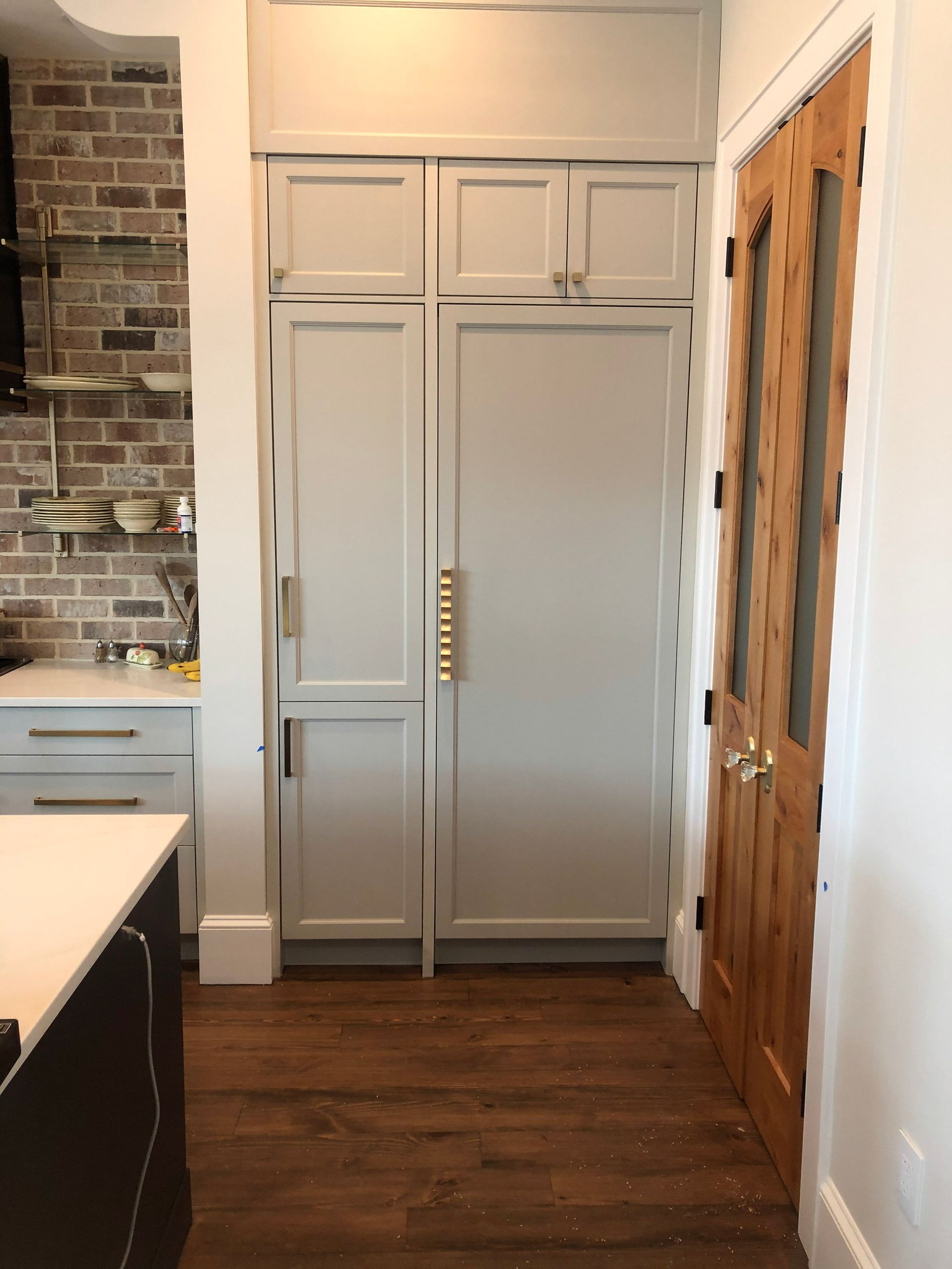 A walk in closet with lots of shelves and a door.